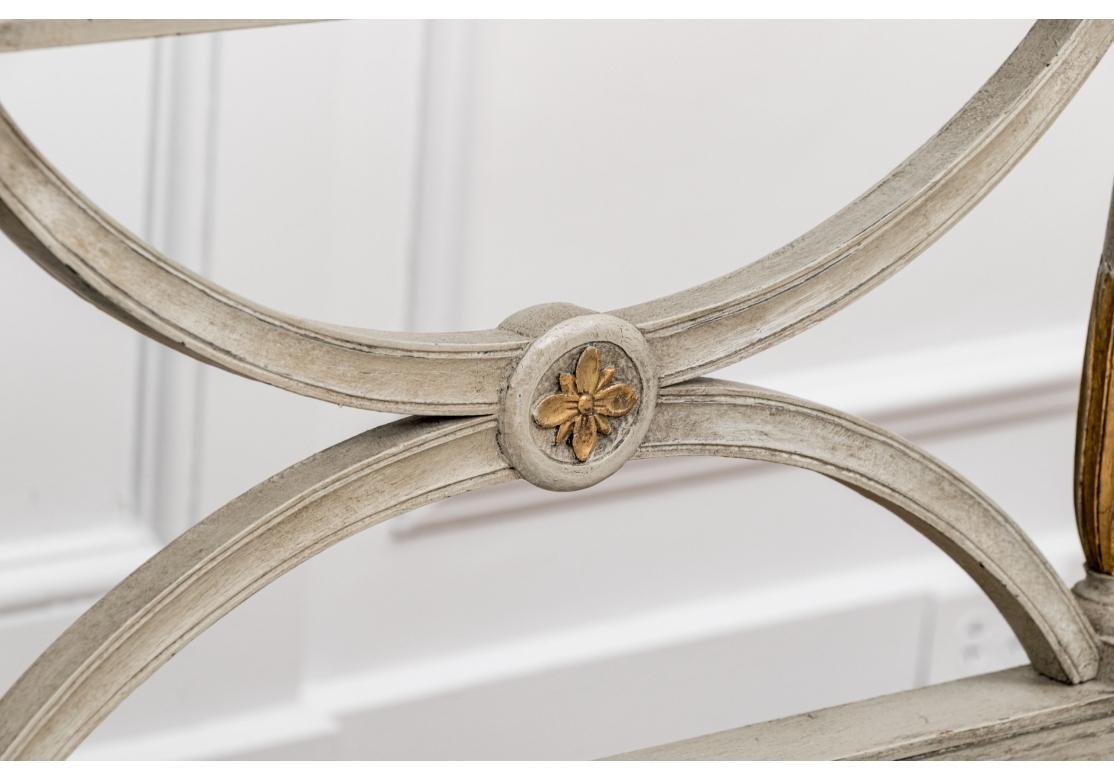 A fine and elegant example of the type of 19th century neoclassical Gustavian paint decorated square frame upholstered sofa. Paint decorated overall in pale gray with gilt details.  Carved and gilt leaf framing bands are around the top back and the