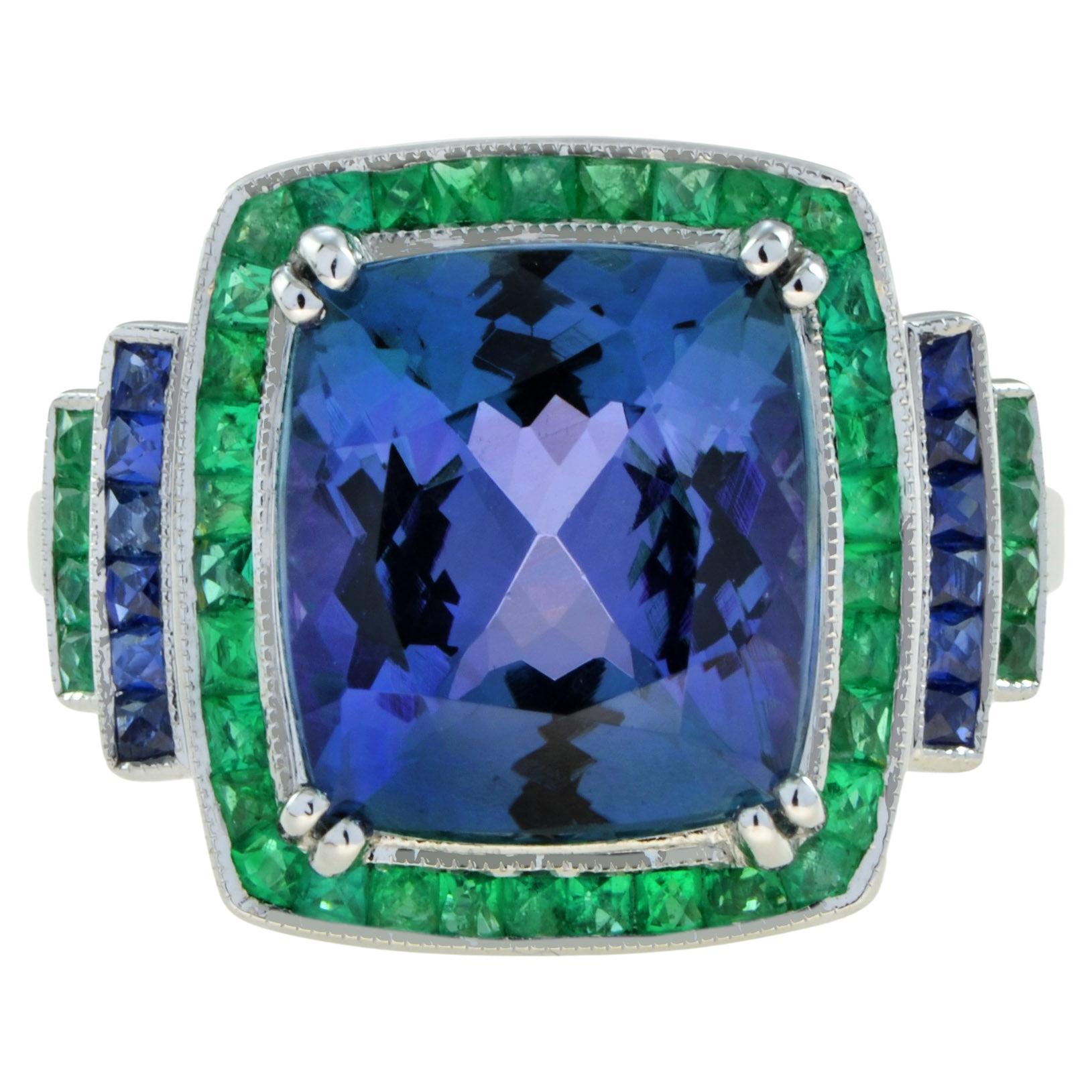 This gorgeous tanzanite cocktail ring crafted of 18k white gold and features and 6.6 carat center stone. It is a very rich and vibrant tanzanite with a beautiful cushion cut. The ring is accented with French cut emerald and sapphire stepped