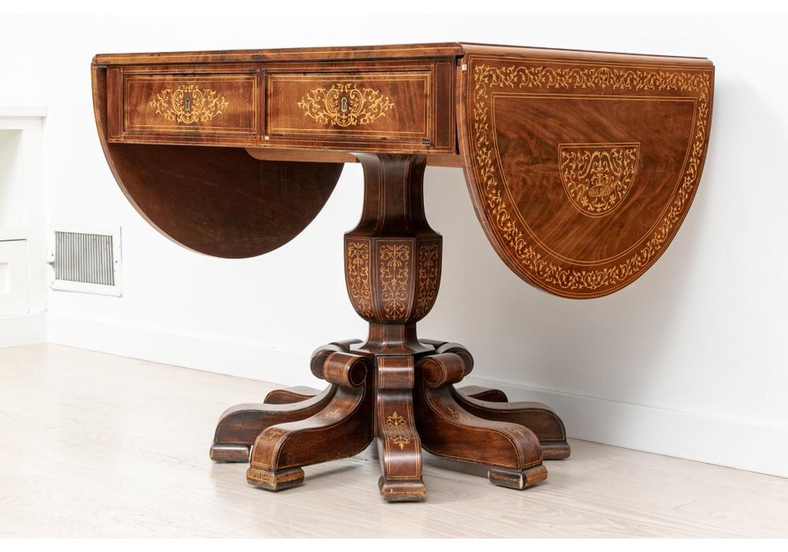 A very fine and complex well-crafted drop leaf table with rectangular top inlaid overall in fine scrolled marquetry details. The top panel with scrolling vines emanating from two vessels, framed by a scrolling vine wide band. Each rounded leaf with