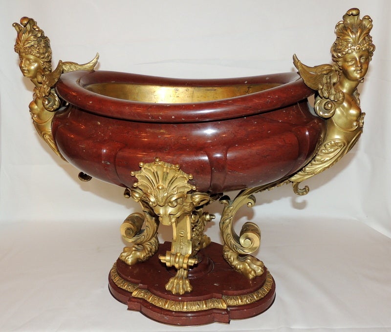 Extraordinary 19th century French rouge marble and doré bronze-mounted centerpiece. Adorned with figural handles, lion heads and claw feet.
Attributed to Barbedienne / Henri Vian.