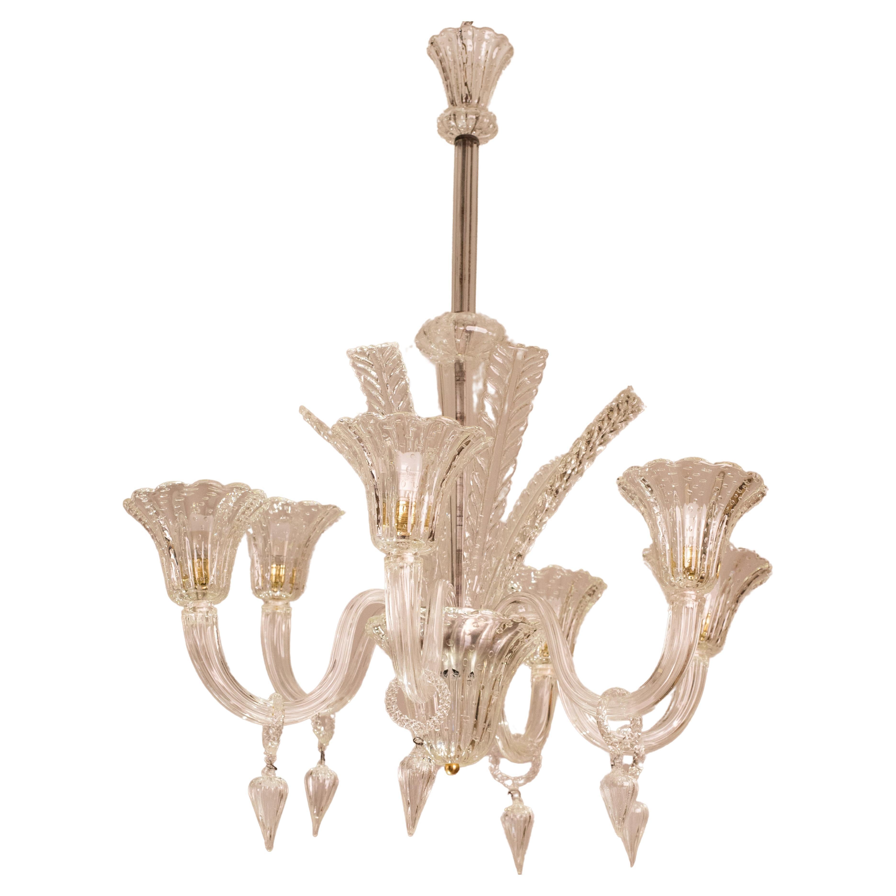 Extraordinaire lustre de Murano provenant des verreries Barovier&Toso.

Période vers 1940.

Le lustre se compose d'un beau tronc central composé de 5 éléments en verre, de six beaux bras avec des coupes en verre 