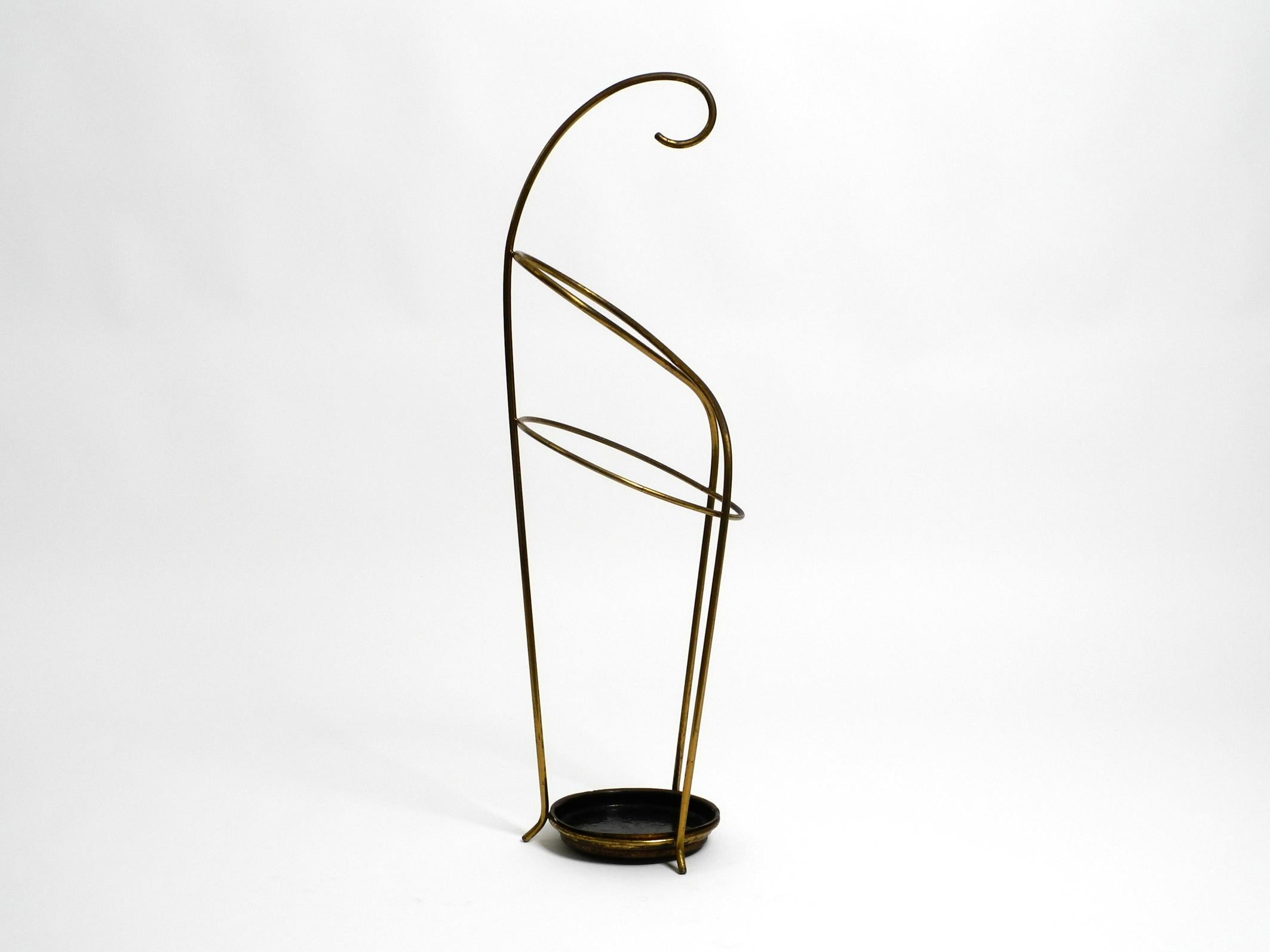 Very elegant, extraordinary Mid Century Modern umbrella stand made of brass and heavy base made of brass and cast iron.
Minimalist typical high-quality 1950s design with brass frame and black lacquered brass bowl with iron plate underneath.
Very