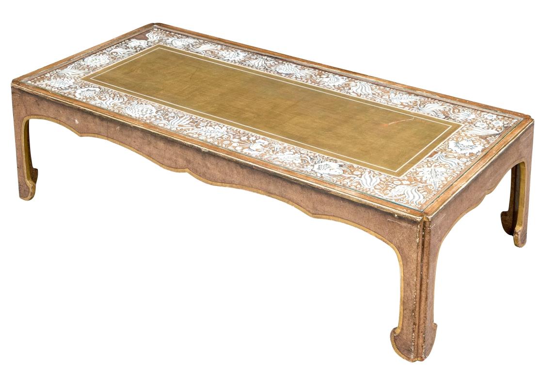 A Hollywood Regency Era low Cocktail Table with gilt edged Ming Dynasty form. The table top has a central gilt panel surrounded by a wide Chestnut tone wood band inlaid with exquisitely cut  and incised bone elements depicting botanical elements