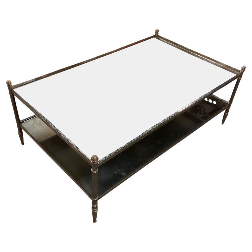 Originally purchased at the eponymous Boston based department store, Jordan Marsh. A beautifully made and very stylish tiered Cocktail Table with a Bronze frame holding two tiers of mottled or “Smoked” Mirror. The frame features delicately fluted