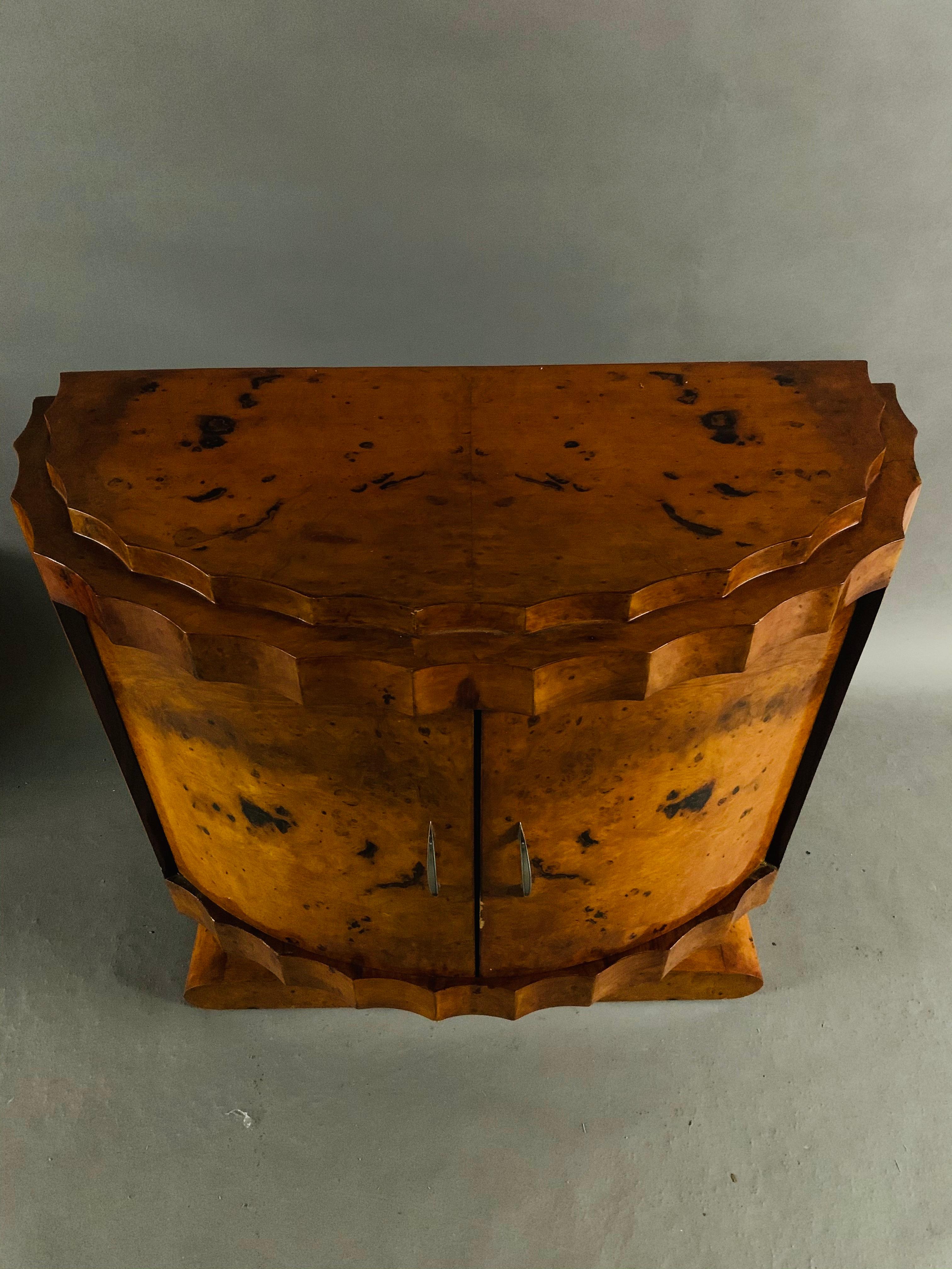 Exotic maple root veneer on solid softwood. Cambered and corrugated body with two double doors on a rectangular base plate. Slightly recessed cover plate. Inside a shelf. Nice patina, hand polish with shellac.