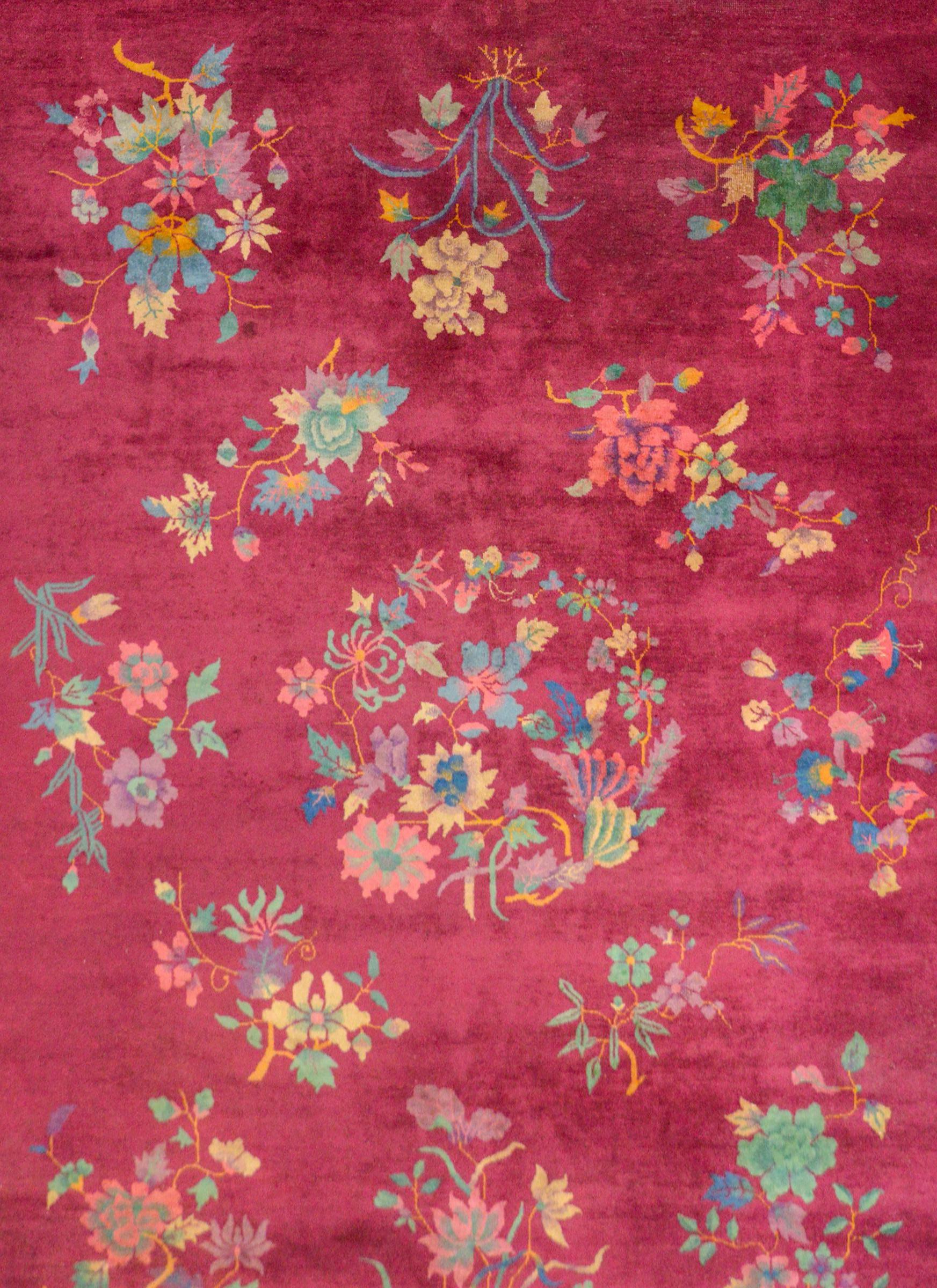 Ein außergewöhnlicher chinesischer Art-Déco-Teppich mit mehreren Büscheln verheißungsvoller Blumen wie Pfingstrosen und Chrysanthemen, Symbole für Langlebigkeit und Wohlstand, auf einem cranberryfarbenen Hintergrund. Die Umrandung besteht aus einem