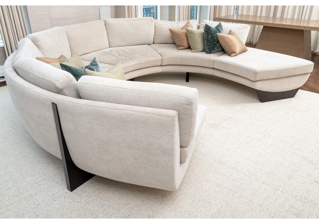 A stunning Custom  five section Circular Sofa meticulously upholstered in a Natural textured Sand tone Cotton type fabric with a very pleasing feel. The various sections are supported by Sculptural and shaped Ebonized wood trestles. The cushioning