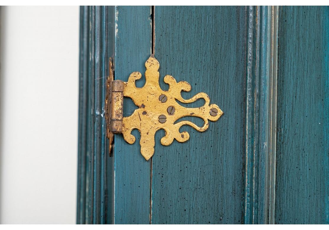 Custom painted in a striking blue exterior with an electric and contrasting green interior and having a strong form, ornate gilt hinges and pulls, escutcheons (with keys) and Top finials, if you’ve been looking for an Over-The-Top Focal Point,