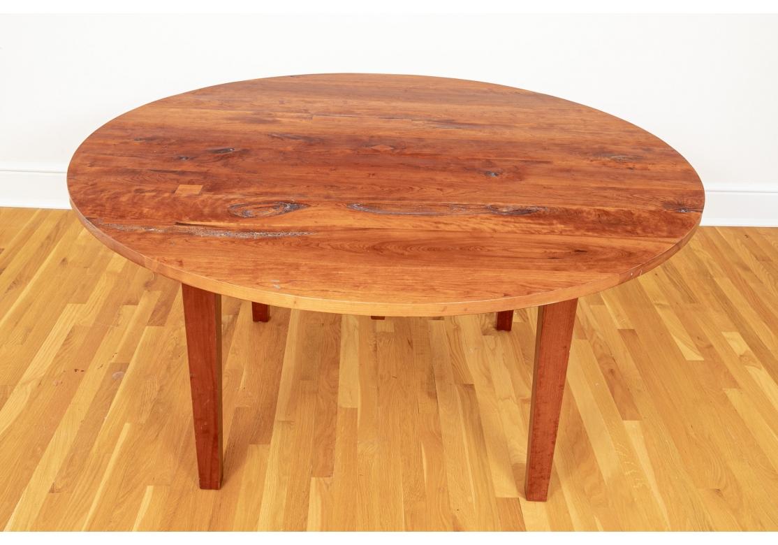 Bench made solid cherry planked dining table with gently tapering legs and having the natural worming, natural irregularities, knots, inlaid butterfly and square joinery inclusions, stable age cracks as part of a sophisticated design. Very solid