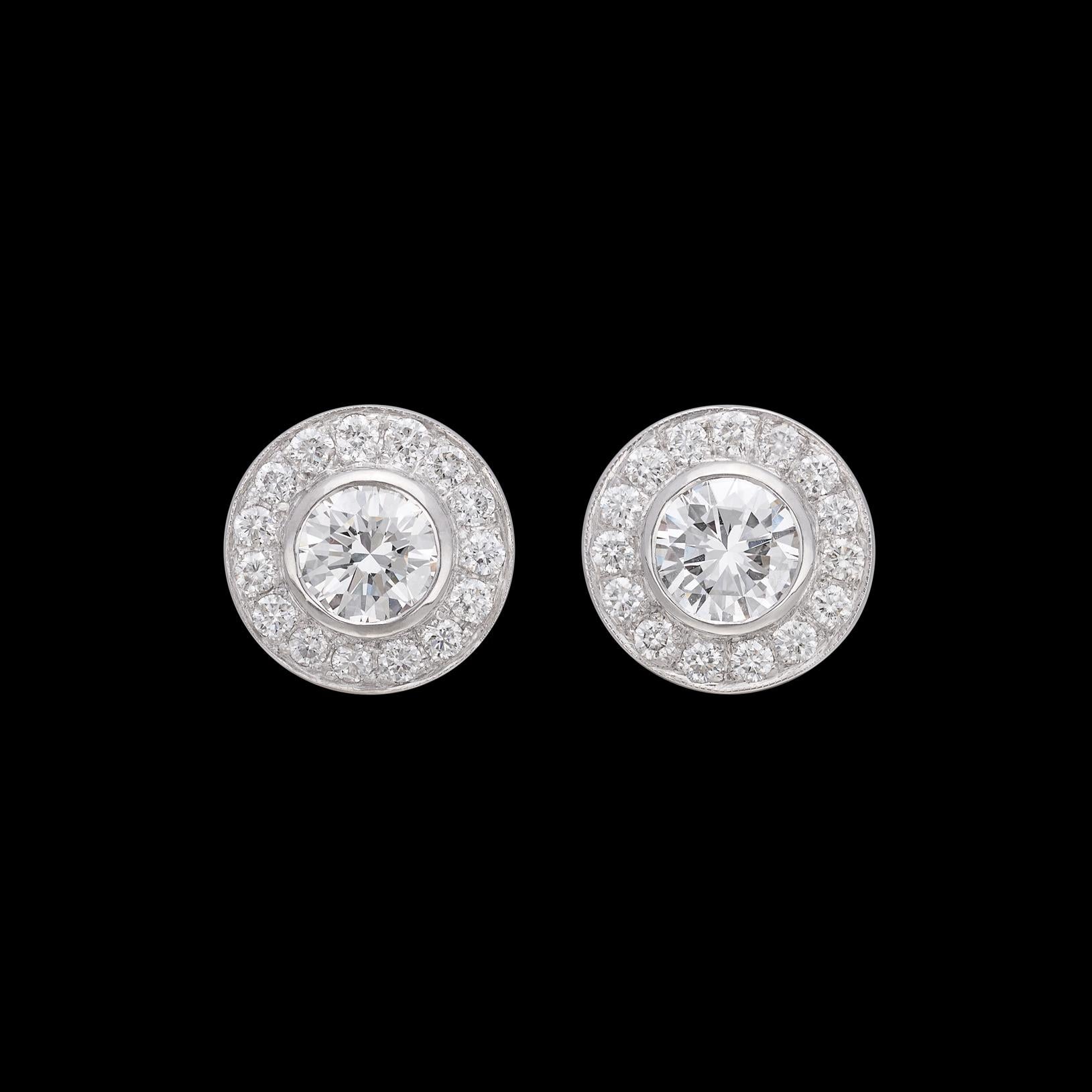Un paio di orecchini da urlo, se mai ce ne fosse uno! Una coppia di eccezionali diamanti rotondi taglio brillante classificati GIA sono sapientemente incastonati in un'aureola di finissimi diamanti melee per 2,99 carati. I diamanti centrali, ben