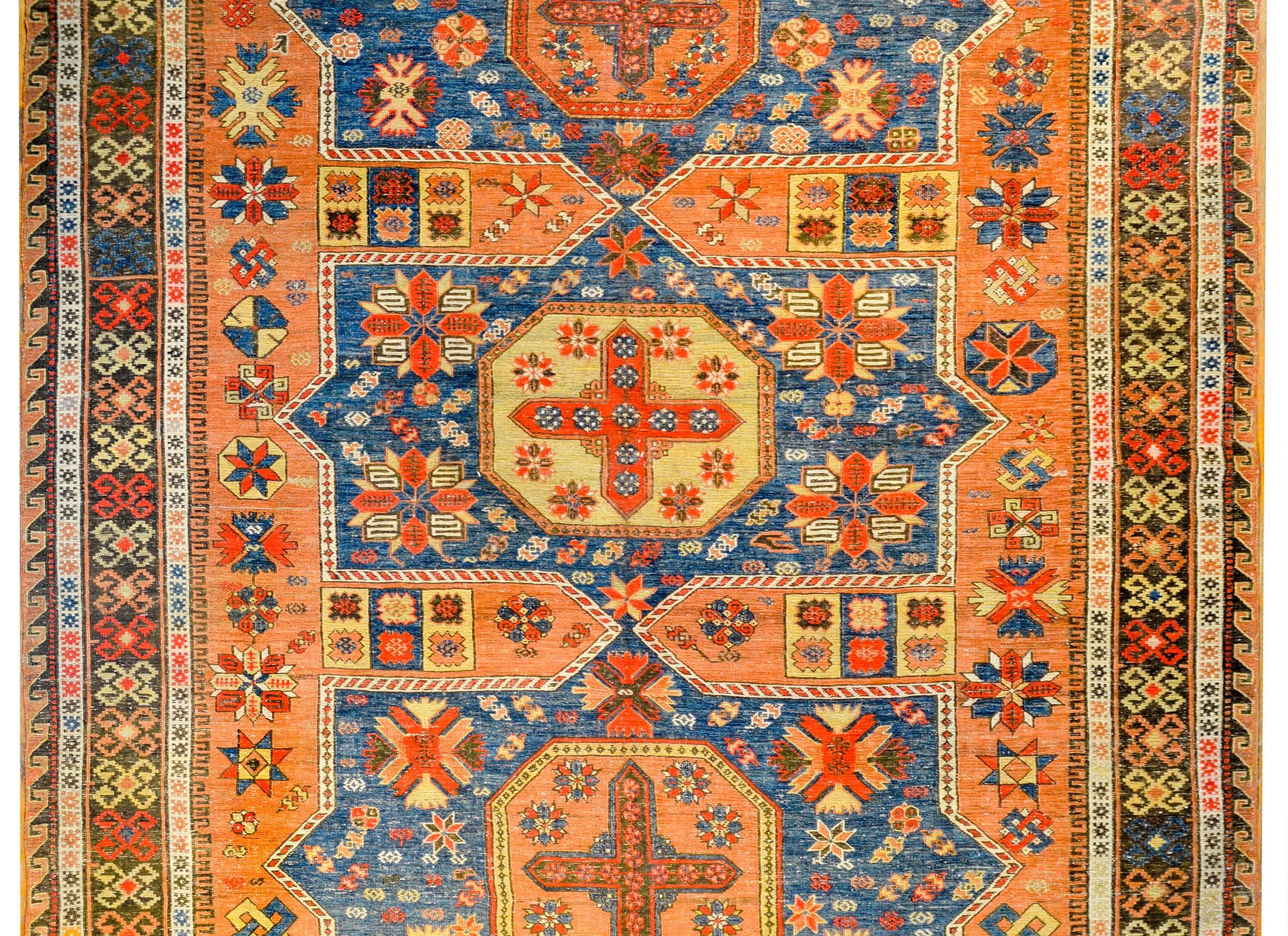 An unbelievable early 20th century Persian Sumak rug with three large octagonal medallions, densely woven with stylized geometric and floral motifs, amidst a field of stylized flowers on an indigo background. The border is masterfully woven with a
