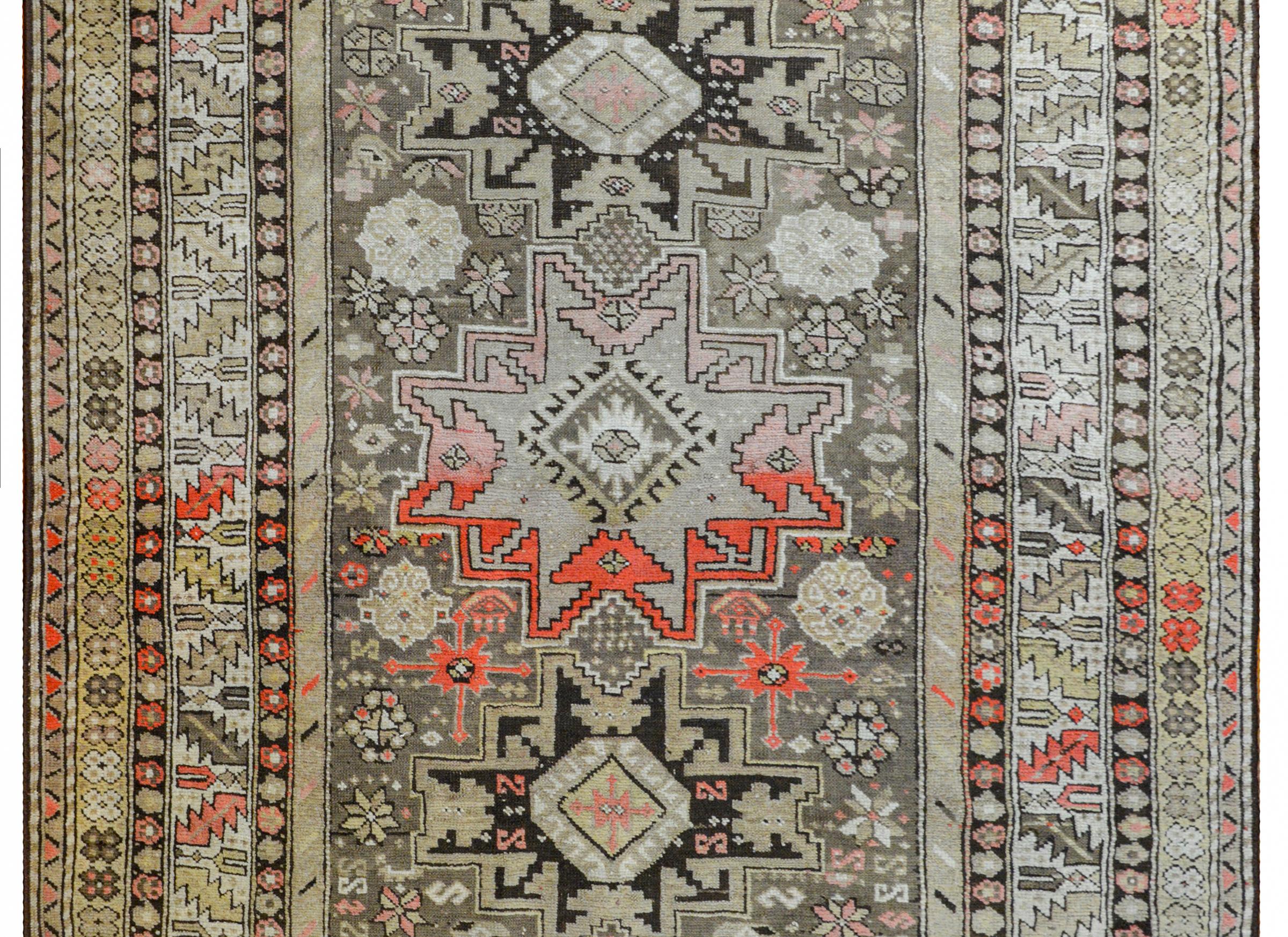 An extraordinary early 20th century Azerbaijani Shirvan rug three large stylized flower medallions amidst a field of more densely woven stylized flowers, all surrounded by myriad floral and geometric patterned stripes and all woven in abrash shades