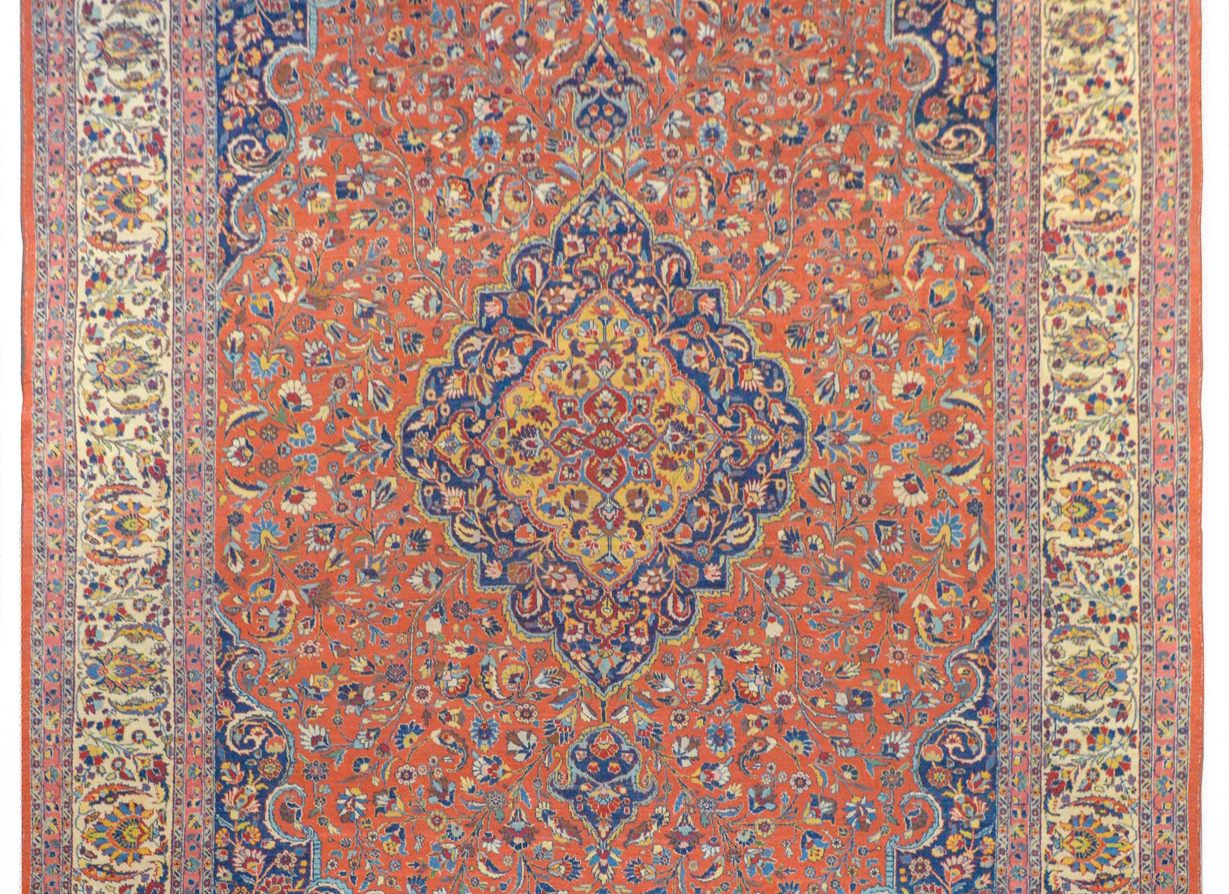 An extraordinary early 20th century Persian Tabriz rug with an elaborate pattern containing multiple central medallions stacked on top of one another, and each with a distinct floral and scrolling vine pattern, all woven in gold, crimson, brown,
