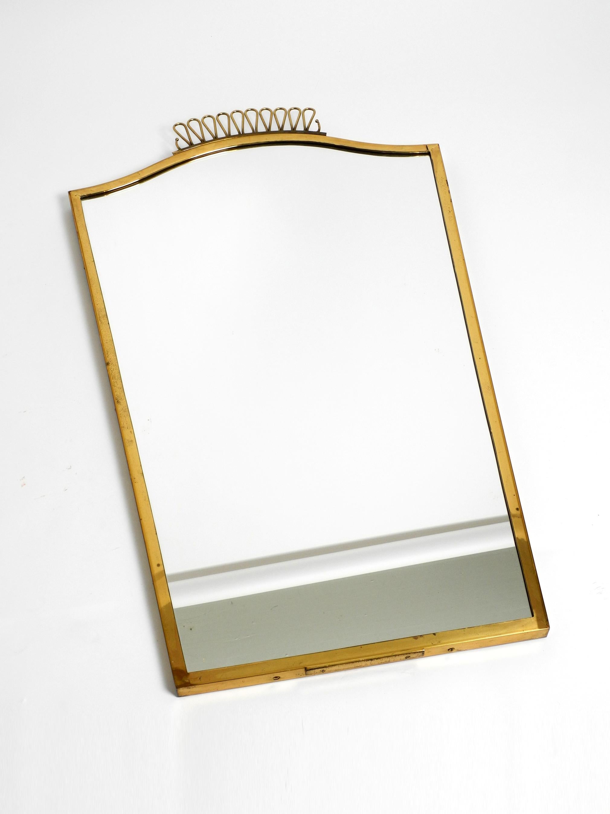 Extraordinary, rare, large, elegant Mid Century brass wall mirror.
Great 1960s design. Very high quality, solid and elegantly processed.
With thick solid brass frame.
Heavy and very solidly built. Weight about 10 kg.
Very good condition with no