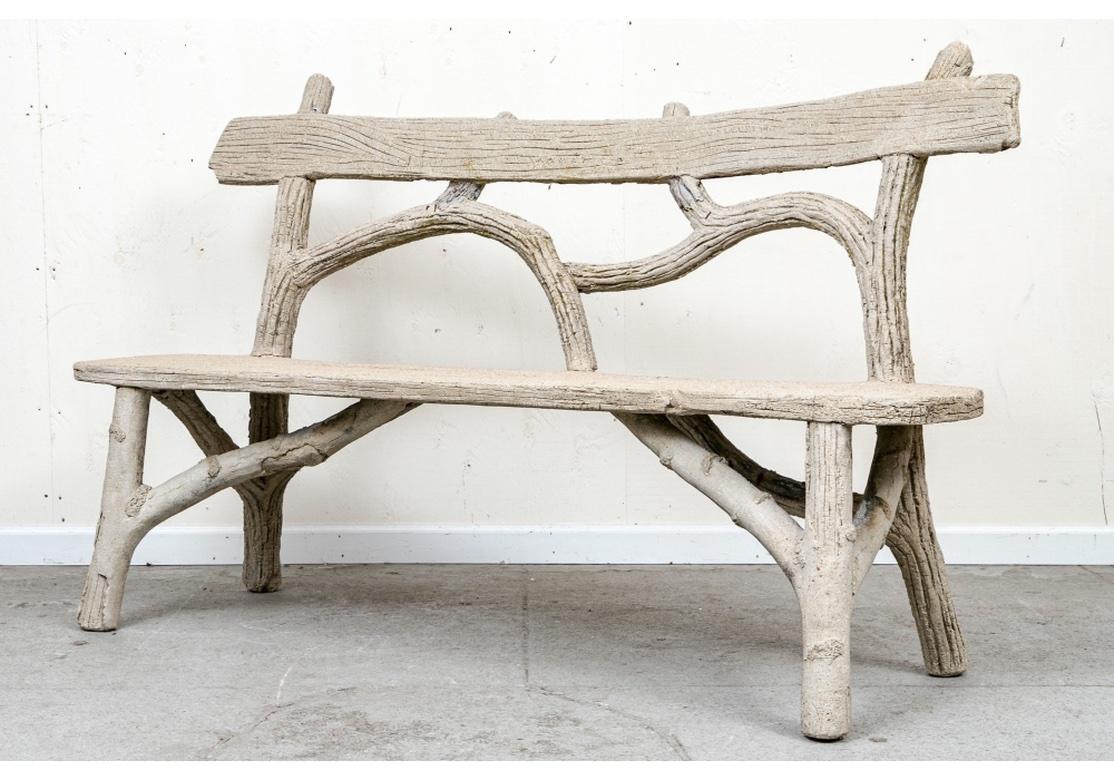 A Classic Garden Bench in cast stone  over an iron framing with all of the various parts recreating Tree Branches and Boards with fantastic detailing including simulated wood graining, peeling bark and faux lichen. The bench is very solid feeling