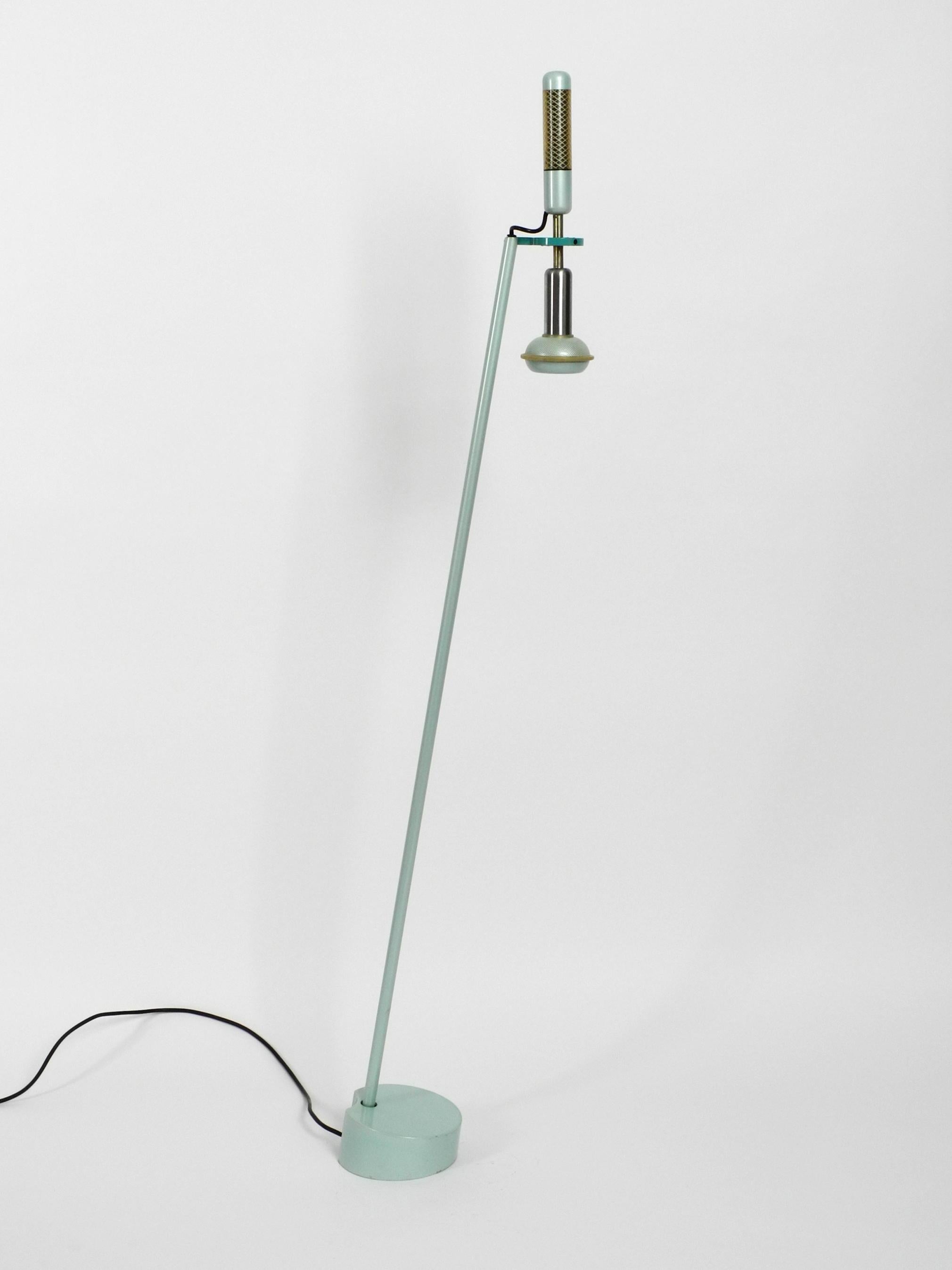 Stunning floor lamp by Achille and Pier Giacomo Castiglioni. 
Manufactured by Flos in 1981. Beautiful in turquoise green. Made in Italy.
Great minimalist Post Modern design from that time.
Completely made of metal with a very heavy base for a