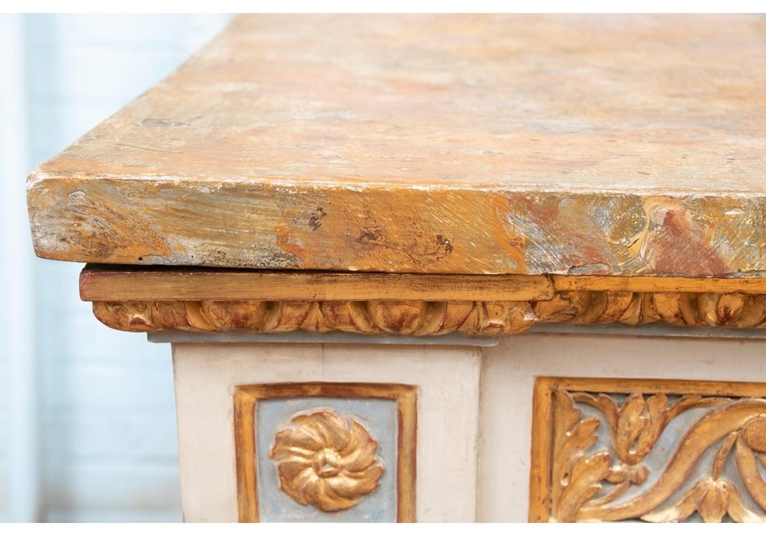 A Neoclassical Style Console with a sophisticated Painted and Gilt finish. Believed to be originally from Italy and re-imagined with fresh Gilding and Paint. The top in variegated paint on brown having intentional distressing over a painted and gilt
