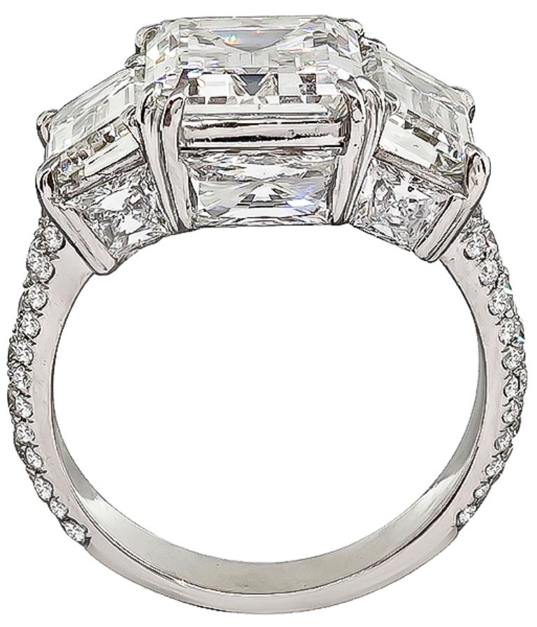This amazing platinum engagement ring is centered with a sparkling GIA certified emerald cut diamond that weighs 4.06ct. graded J color with VS2 clarity. The center stone is flanked by 2 GIA certified emerald cut diamonds that weigh 1.43ct graded G
