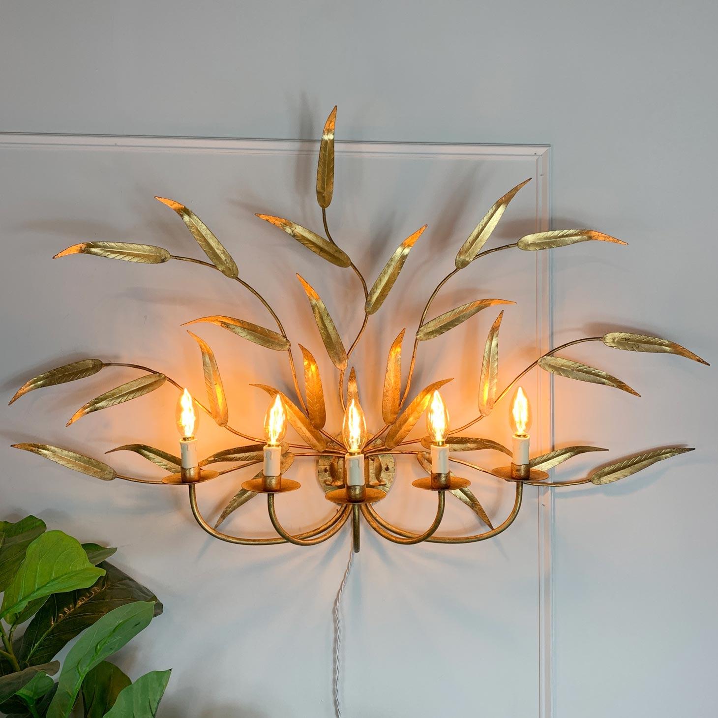 A super gilt iron wall light of enormous proportions, by Ferro Art, Spain. Detailed gilt leaves profusely decorate the light, while the five single bulb lamp holders stretch out from the central rose on curved arms.

The gilt is in fabulous
