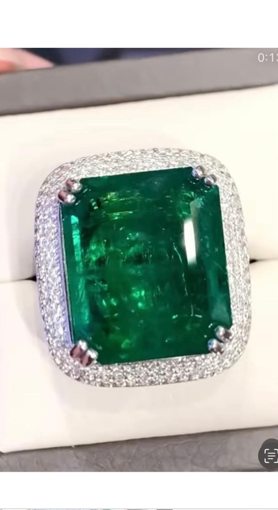 Ein exquisiter und seltener großer Sambia-Smaragd von 26 Karat, feiner Grad und Qualität, sehr hartes Stück, spektakuläres Grün, auf einem zeitgenössischen Ringdesign in 18k Gold mit runden Diamanten im Brillantschliff 1,10 Karat F/ VS. 
Es handelt