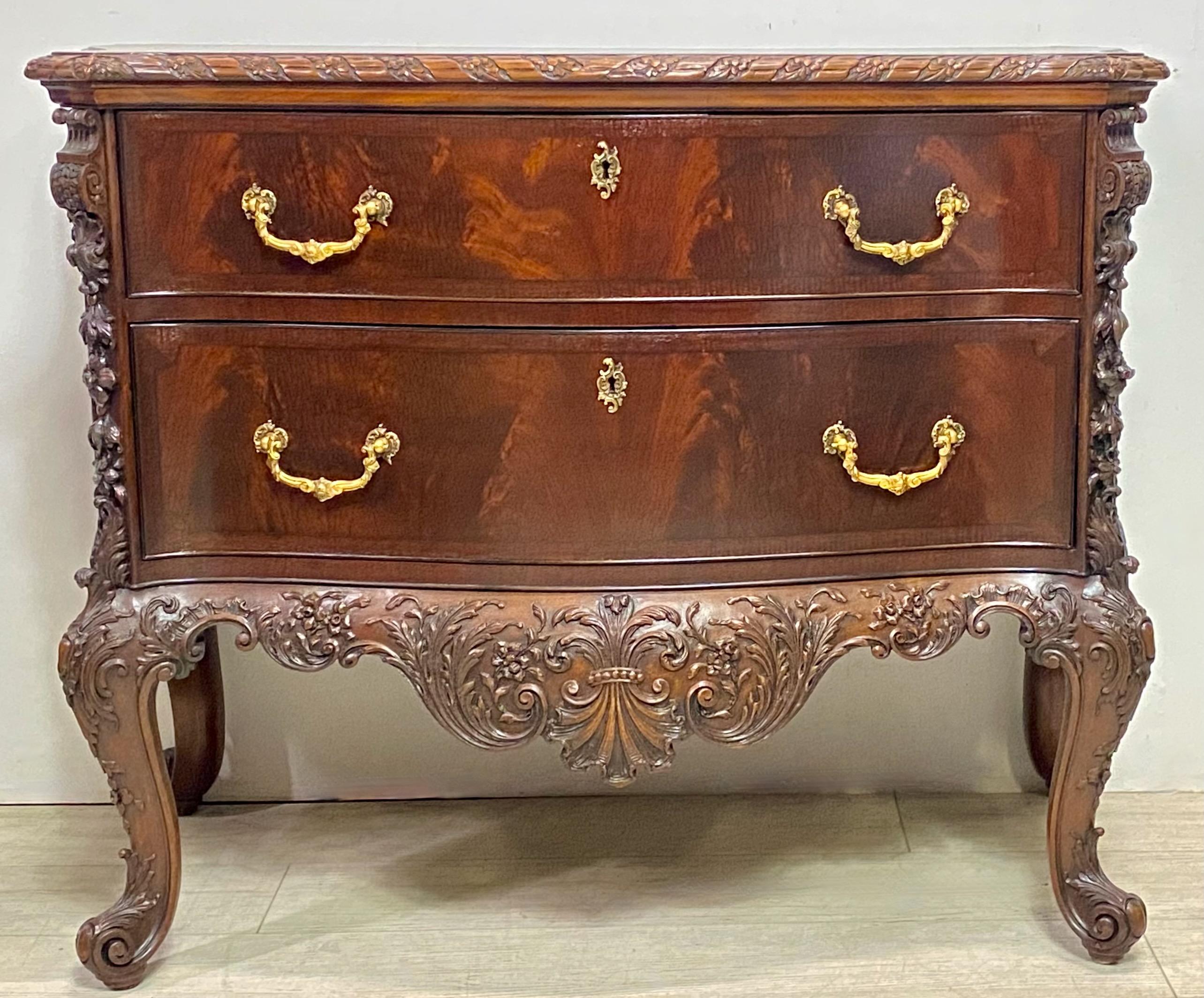 An exceptional bench-made hand crafted solid mahogany two drawer chest with elaborately carved detail, sitting on cabriolet legs and scroll feet with brass pulls. 
100 percent mahogany with crotch veneer over solid mahogany drawer fronts.
This is