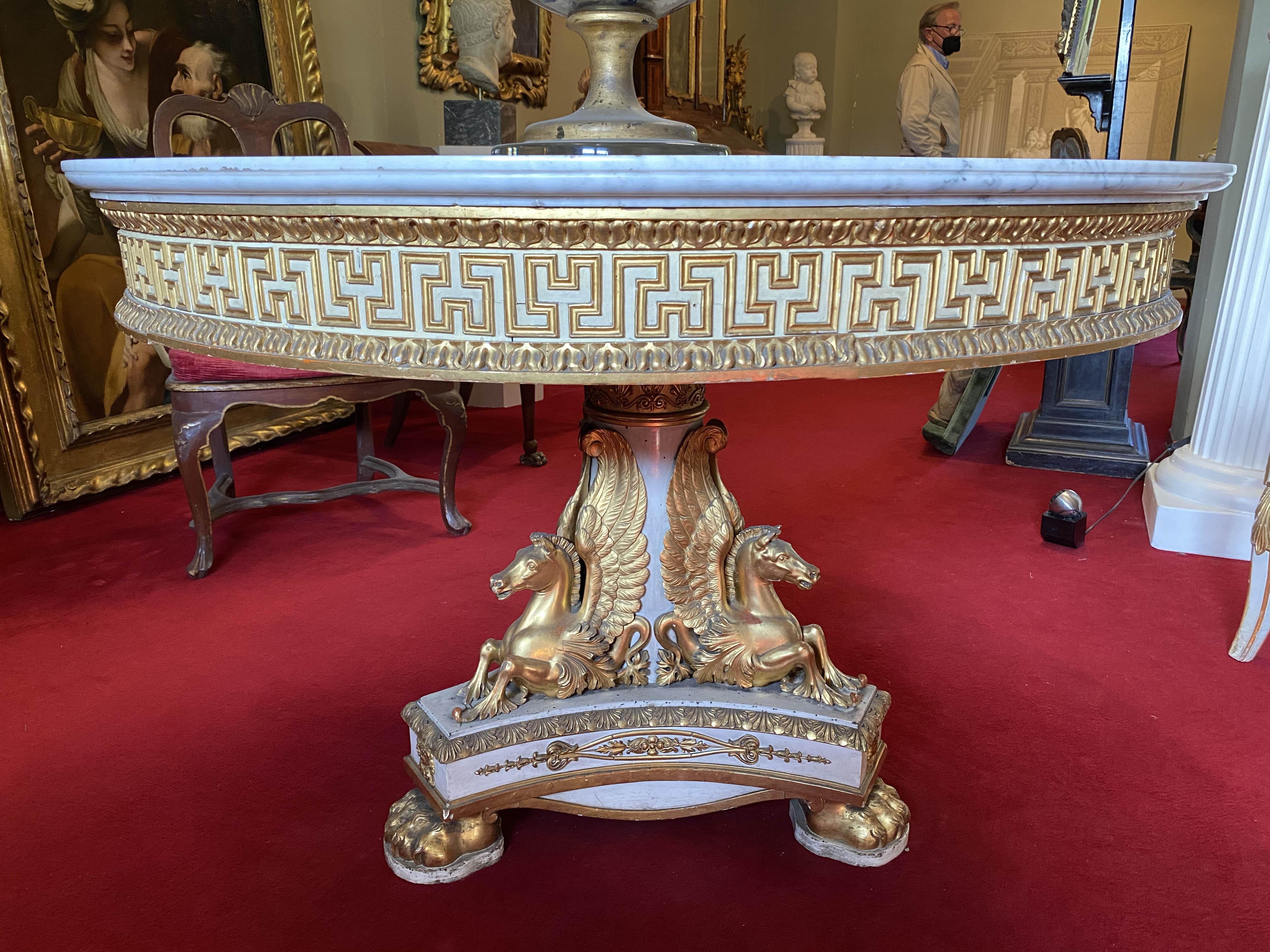 Rare and exceptional Italian ivory painted and parcel-gilt center table with a circular Carrara marble top above triple addorsed finely carved winged horses on a triform base with lion feet. Designed by Domenico Moglia.
Published; Il mobile Impero