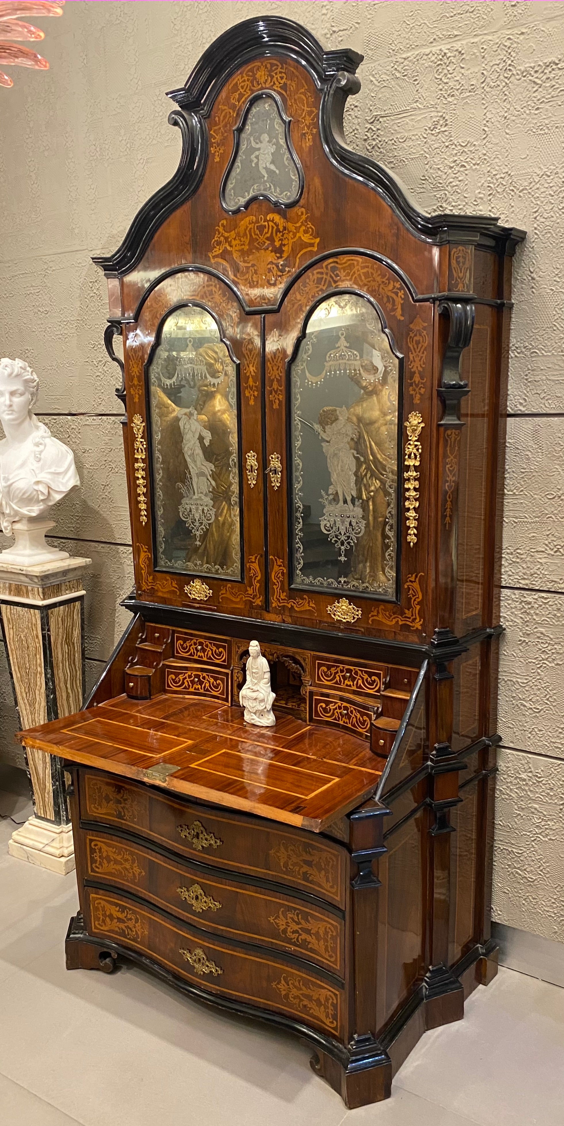 Outstanding Italian walnut, parquetry bureau cabinet fruitwood inlaid with scrolling foliage,
The upper section with a shaped carved cresting centered by a cartouche-shaped mirror with 
 engraved putto figure. Above a pair of mirrored doors,