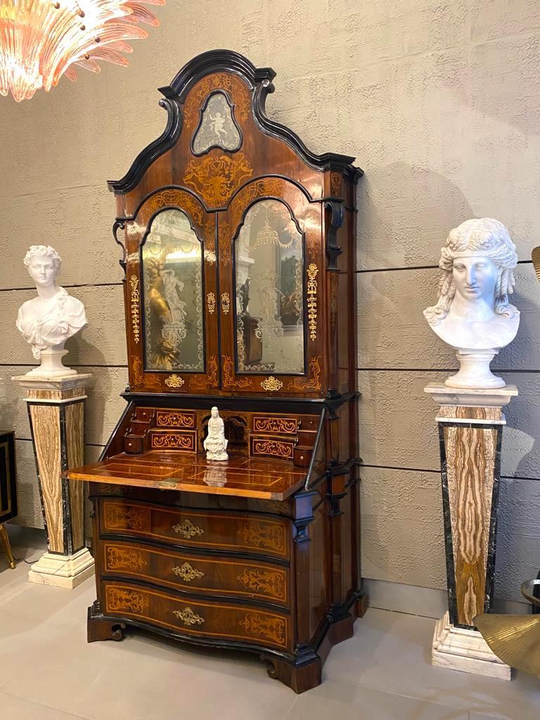 Eccezionale esemplare italiano del 18° secolo  mobile bureau in noce, parquet, legno di frutta intarsiato con fogliame a volute,
La sezione superiore con una cresta sagomata intagliata centrata da uno specchio a forma di cartiglio con 
 figura di