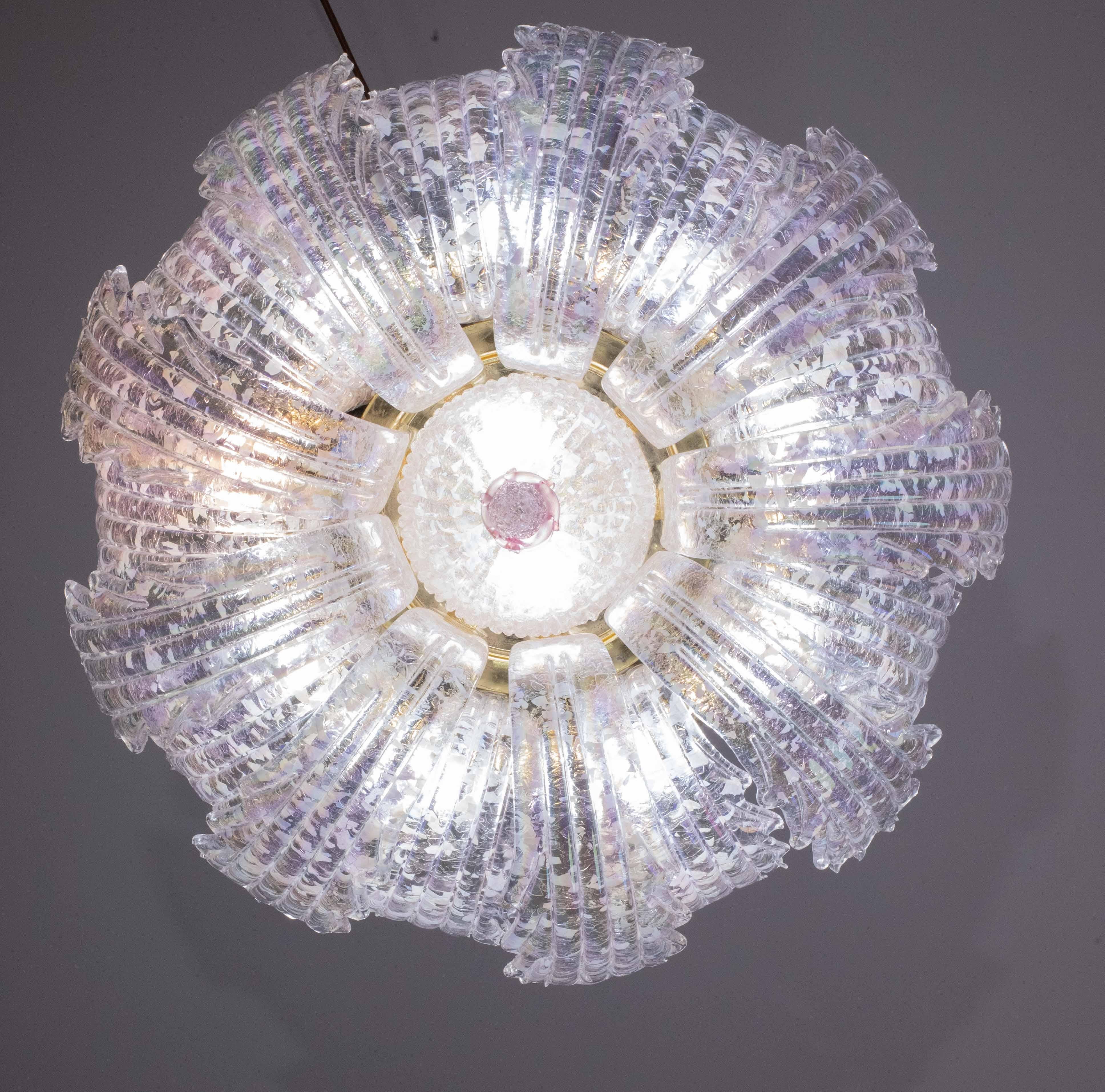 Straordinaria plafoniera rosa cangiante di Murano.
La plafoniera è composta da bellissime foglie iridescenti che partono dal centro verso l'esterno, dalla piastra centrale e da un bellissimo elemento rosa.
La plafoniera monta 12 portalampada con