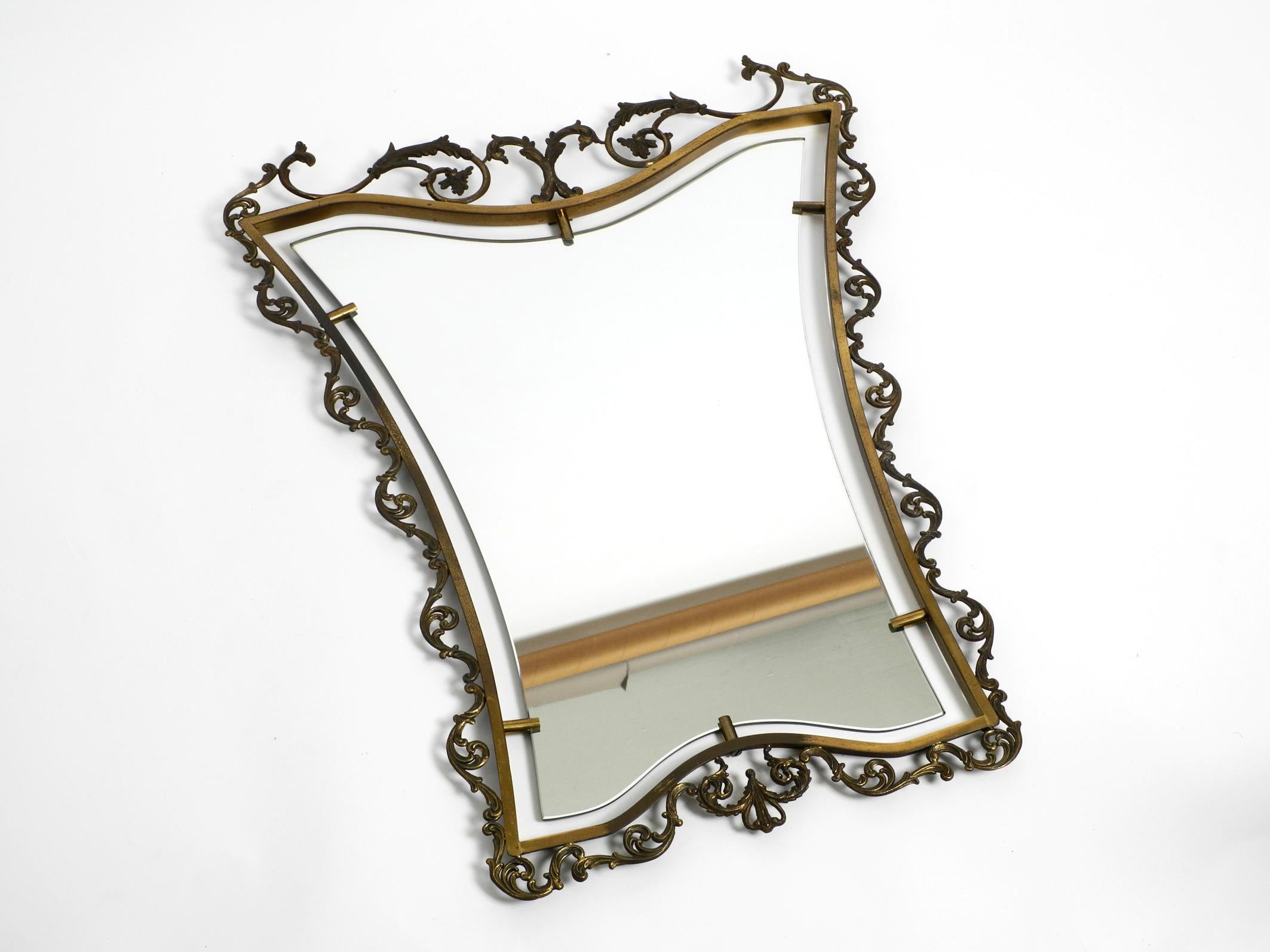 Extraordinary large heavy Mid Century Italian wall mirror with an ornate brass frame.
Great, elaborate design with a decorated brass frame in a diabolo shape.
Very good vintage condition without damage, with a wonderful patina on the brass.
No