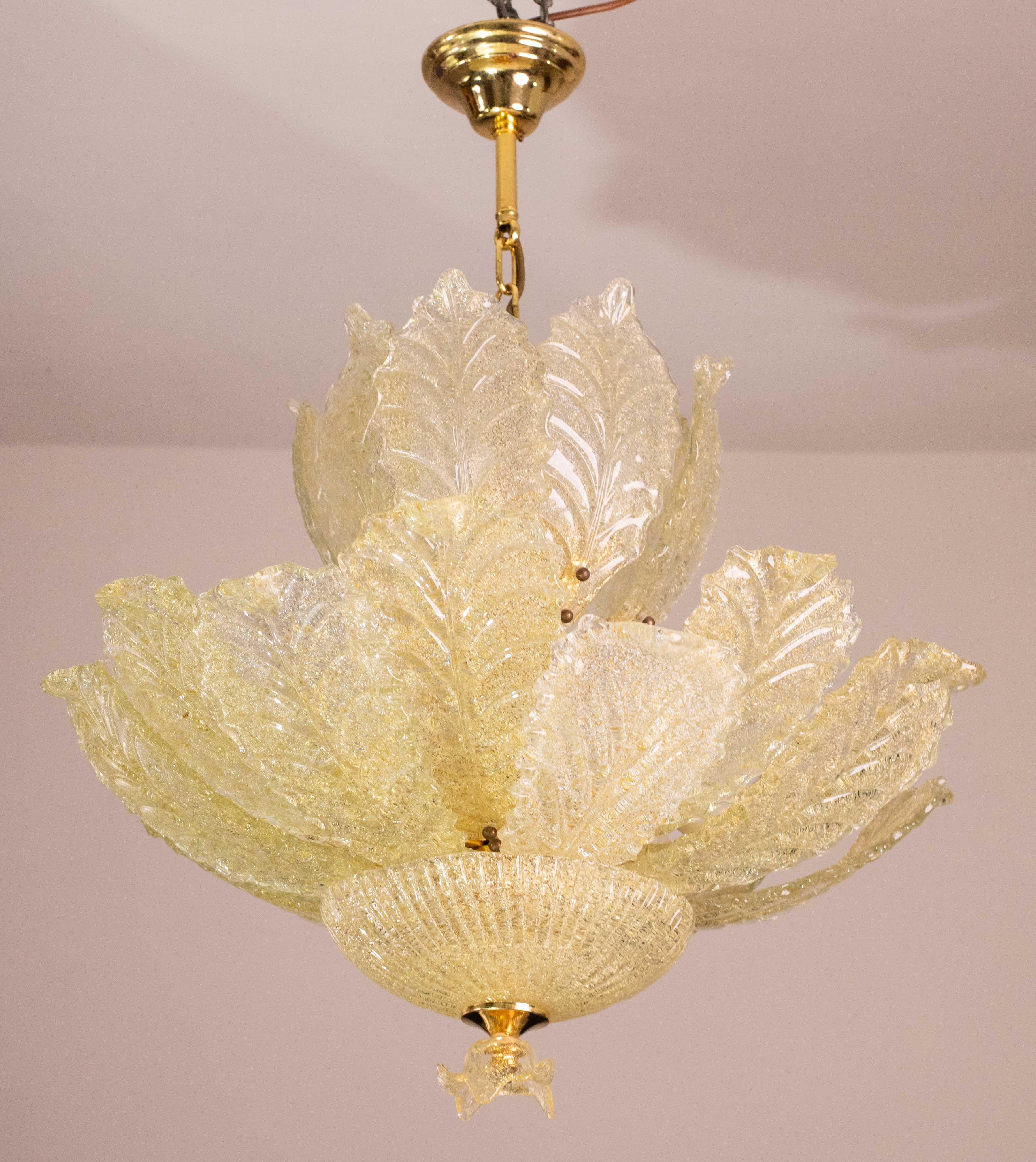 Außergewöhnlicher Kronleuchter aus Murano-Glas in Goldfarbe.
Der Kronleuchter besteht aus zwei Ebenen von Blättern, die hohe Ebene besteht aus 8 Blättern, kleinere.
Die untere Ebene besteht aus 8 größeren Blättern, der Verschluss wird durch einen