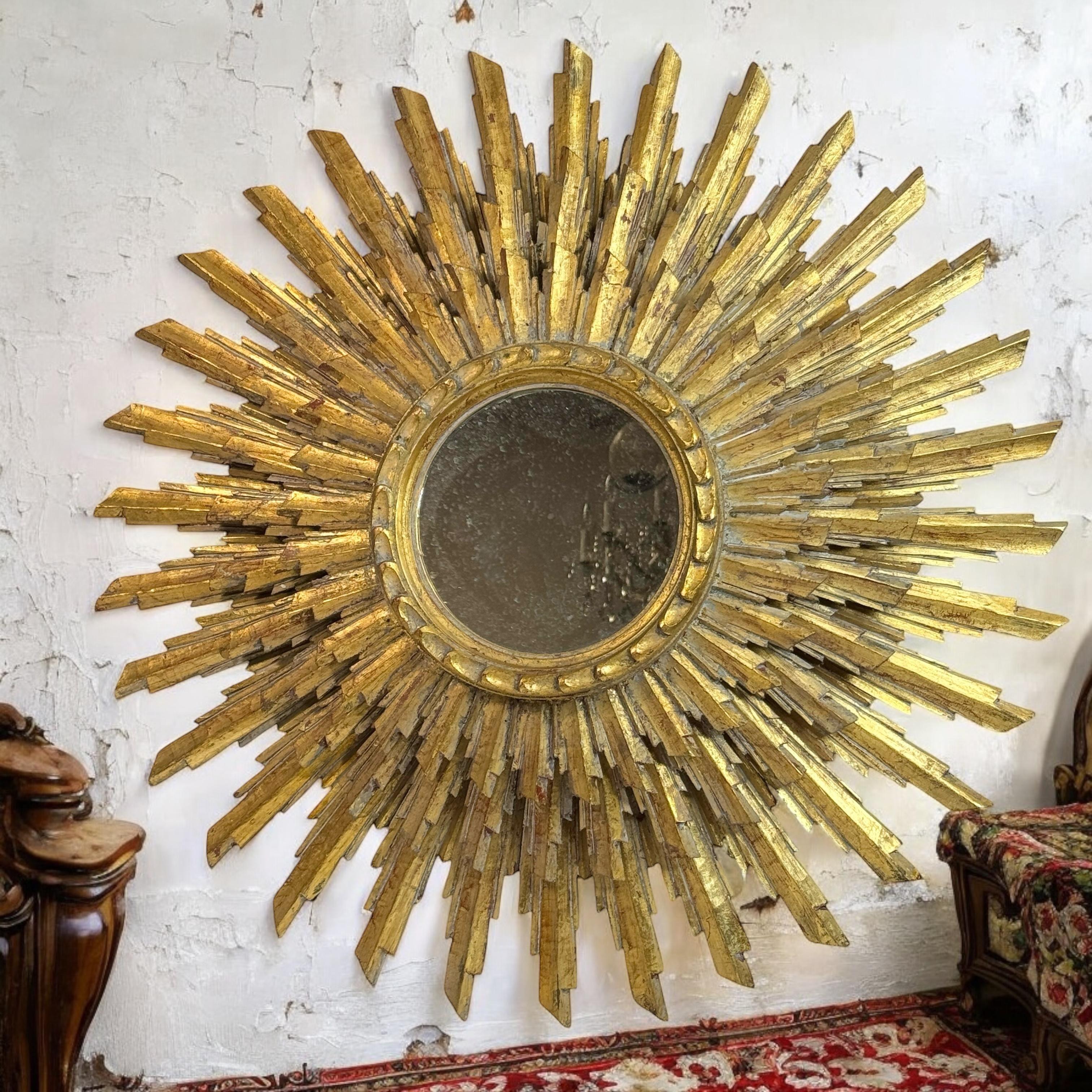 Un magnifique miroir plat en forme de soleil ou d'étoile. Fabriqué en bois doré à trois couches. Il mesure environ 27 pouces de diamètre. Le miroir lui-même a un diamètre d'environ 6,88 pouces. Il se trouve à environ 3.75