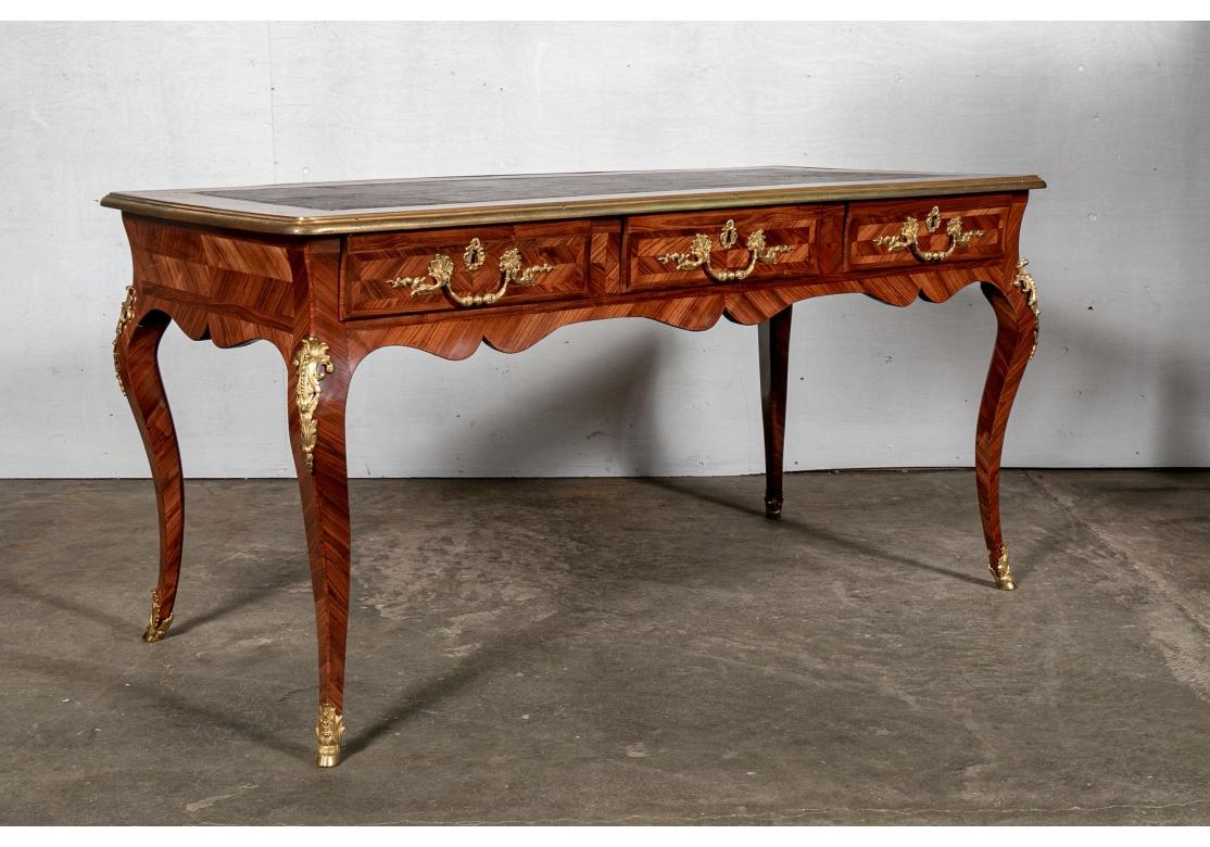 Originally acquired through Internationally acclaimed Paris based Interior Designer Juan Pablo Molyneux. A Magnificent Mahogany Bureau Plat with six drawers, Intricate Marquetry design, Gilt Brass handles and mounts and cabriolet legs. Leather