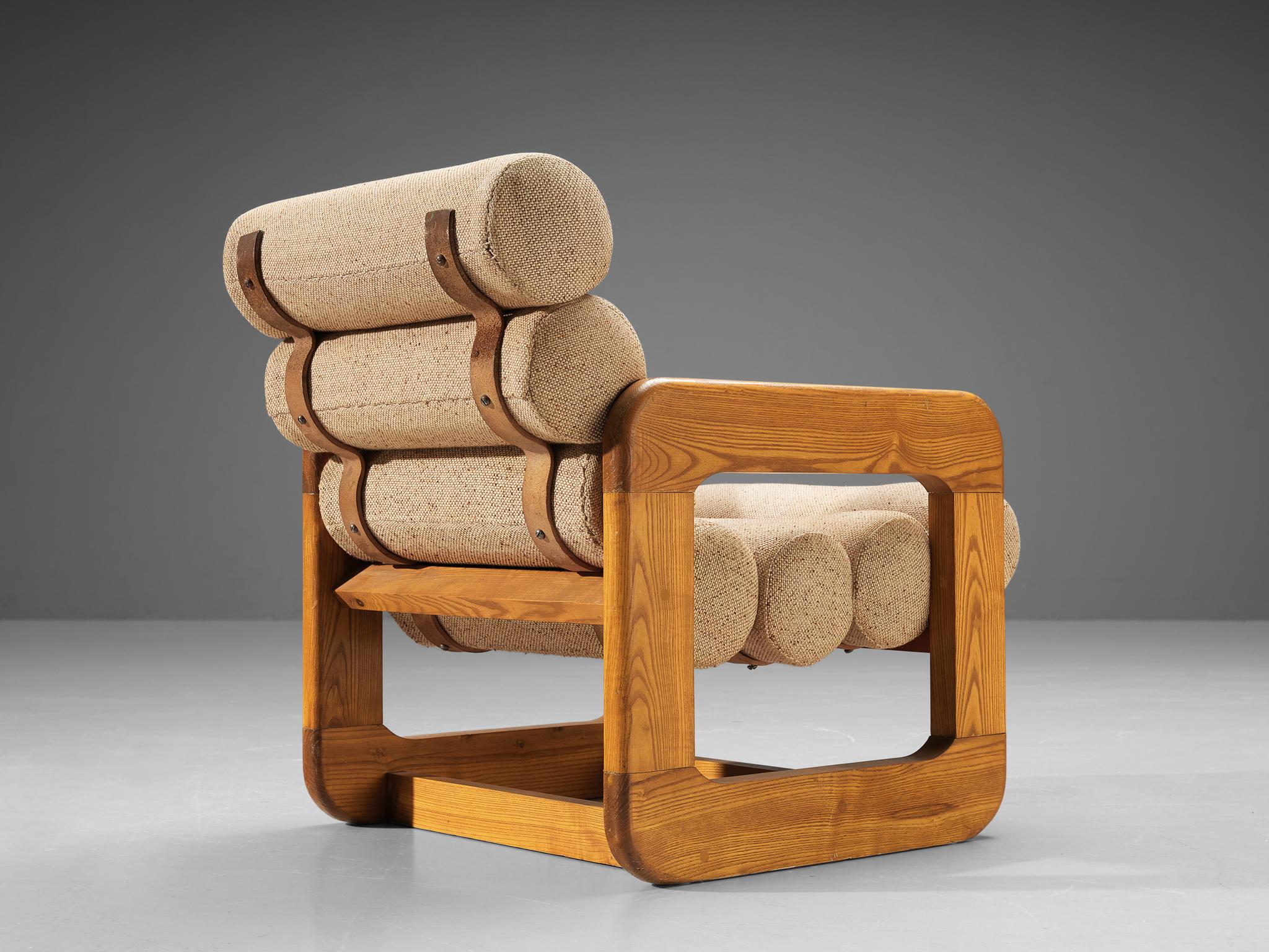 Lounge chair, ash, fabric, metal, Europe, 1970s. 

Unconventional lounge chair that features an outstanding design. The seating contains multiple tube-shaped cushions attached together to create a seat and backrest. The repetition of the rounded