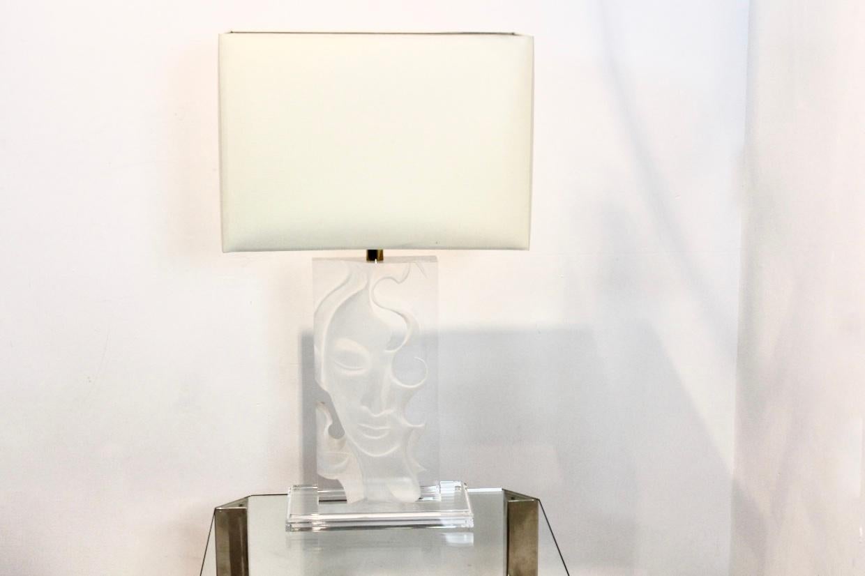 Unique et magnifique lampe de table en Lucite et laiton des années 1970. La lampe a deux visages dessinés dans la Lucite, l'un sur la face avant et l'autre comme un visage de Bouddha caché dans la Lucite. Selon l'angle sous lequel on regarde la