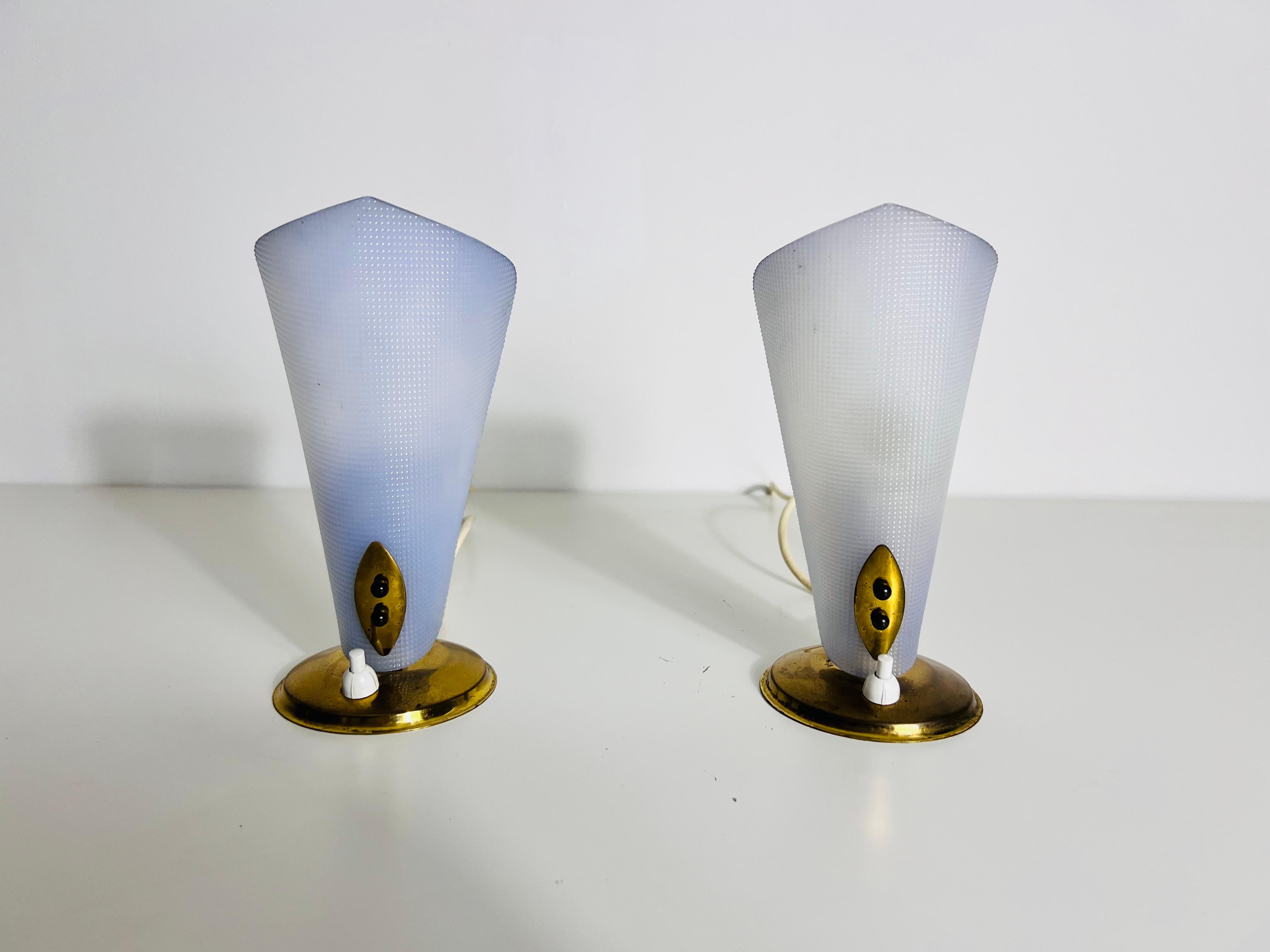 Dieses exquisite Paar Tischlampen, das in den 1960er Jahren in Italien hergestellt wurde, verkörpert die Eleganz und Innovation des modernen Designs der Jahrhundertmitte, insbesondere im Stil von Stilnovo. Die Lampen sind in einer raffinierten