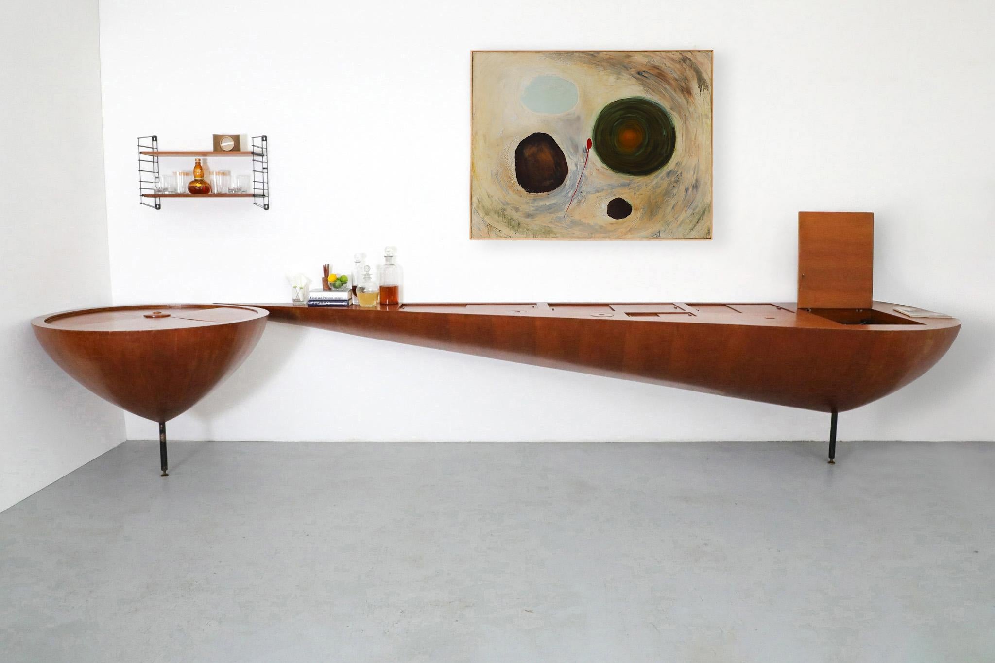 An extraordinary and rare Mid-Century wall-mounted teak console, exquisitely crafted and evocative of the visionary work of Italian designer Ico Parisi. Strikingly sculptural and highly functional, this dramatic piece bridges the line between
