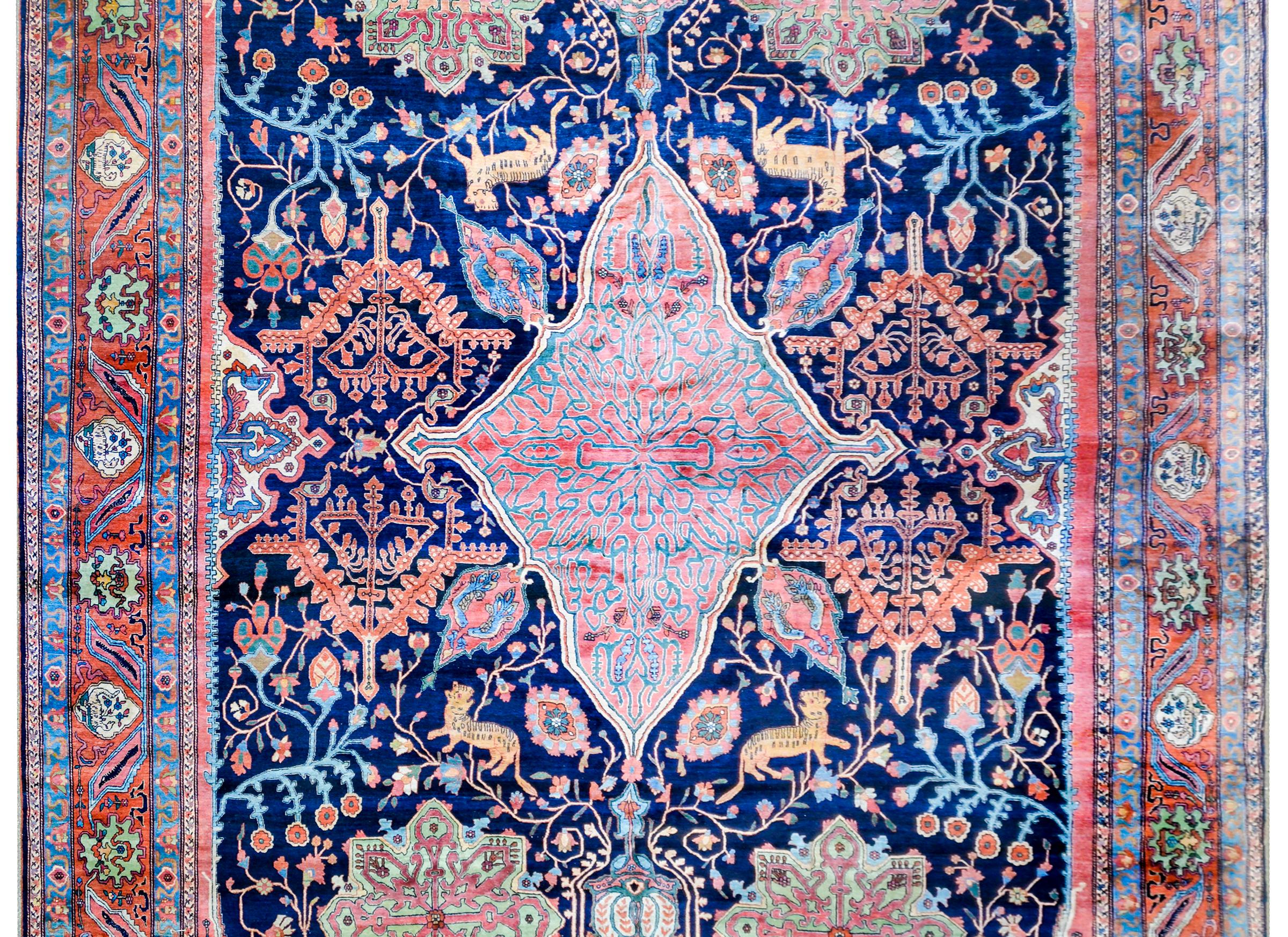 An extraordinary monumental 19th century Sarouk Farahan rug with the most incredible crimson and indigo diamond medallion amidst the most incredible scrolling vine and myriad flowering branch patterned field on a bold dark indigo background. Hungry