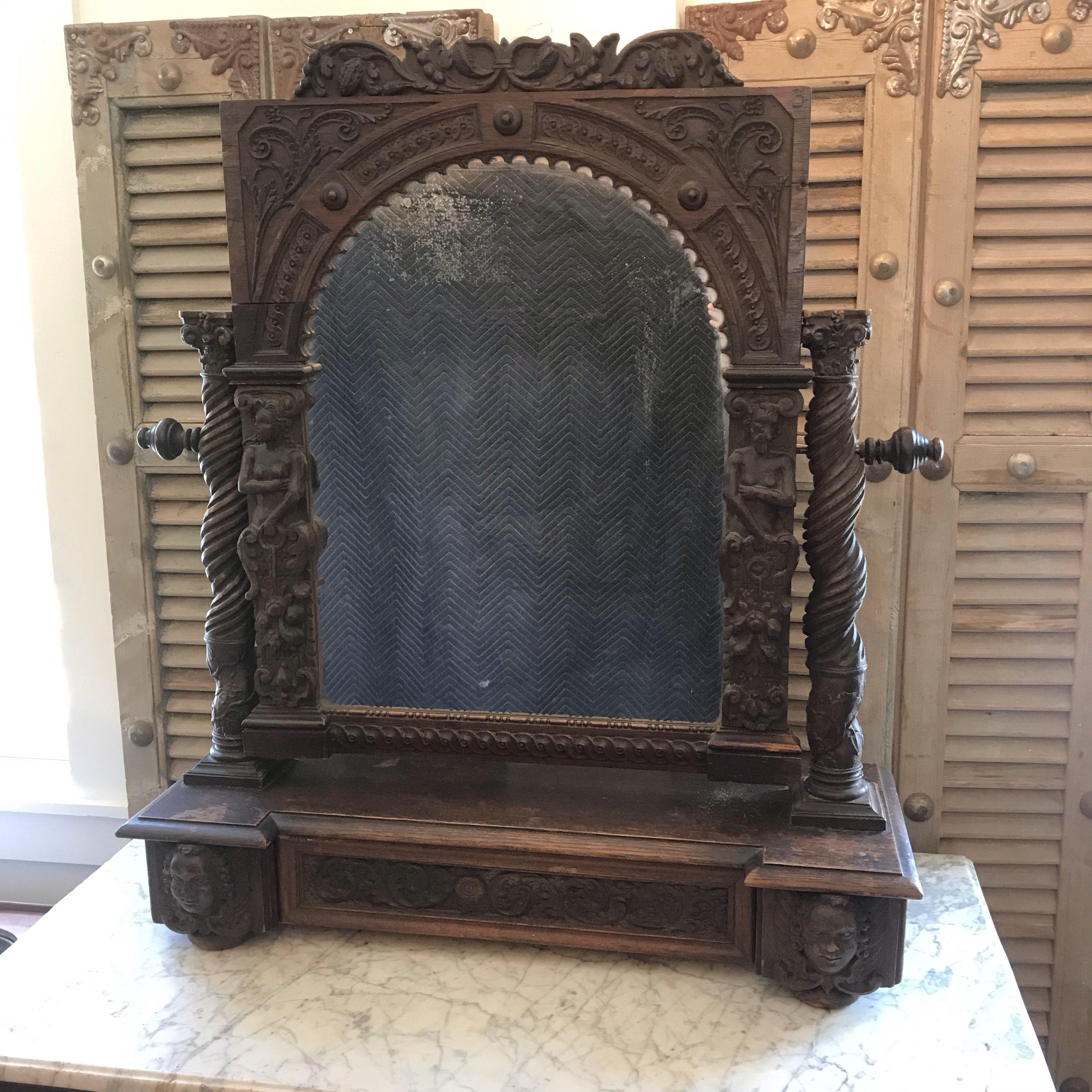 An amazing carved dark oak tabletop mirror having incredible craftsmanship and sculptural qualities with figures, faces, and ornate carved decoration everywhere, as well as a single drawer at the bottom. A true work of art. #5274