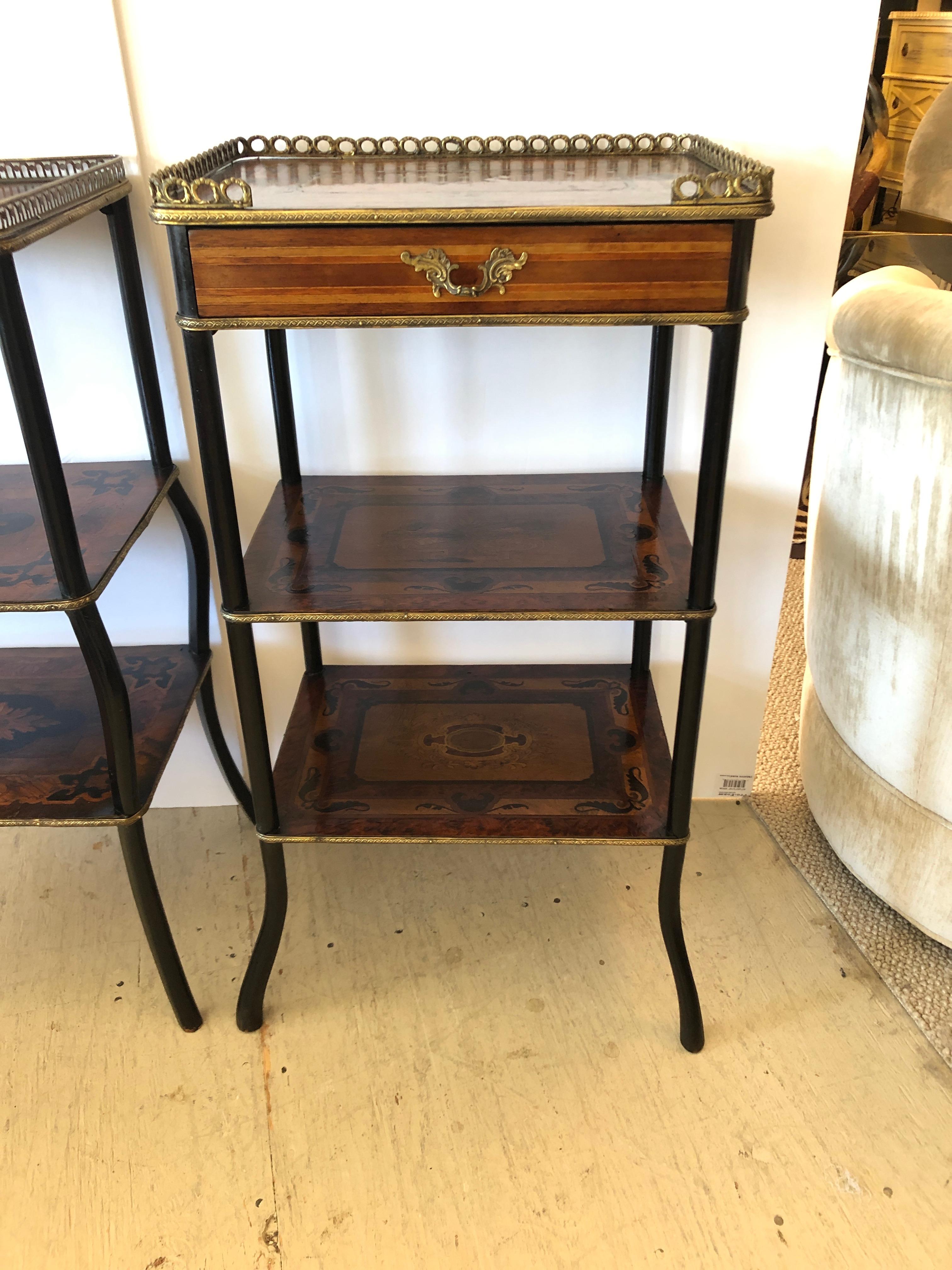 An extraordinary pair of 19th century 3-tier side tables that are even more visually interesting in their variations, they are not an exact match.
Each has intricate mahogany, satinwood, ebony and burl wood inlay, bronze galleries and bronze frames