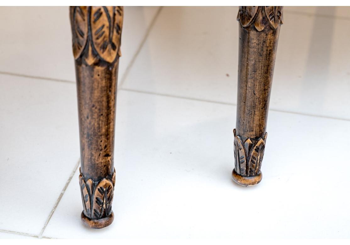 An exceptional pair of club chairs with intricately carved frames with bold Rams Head arms. The generous seats and backs are custom upholstered in a fine and deep Celadon hue faux sued with nail-head trim. . The fine carving covers the frame with