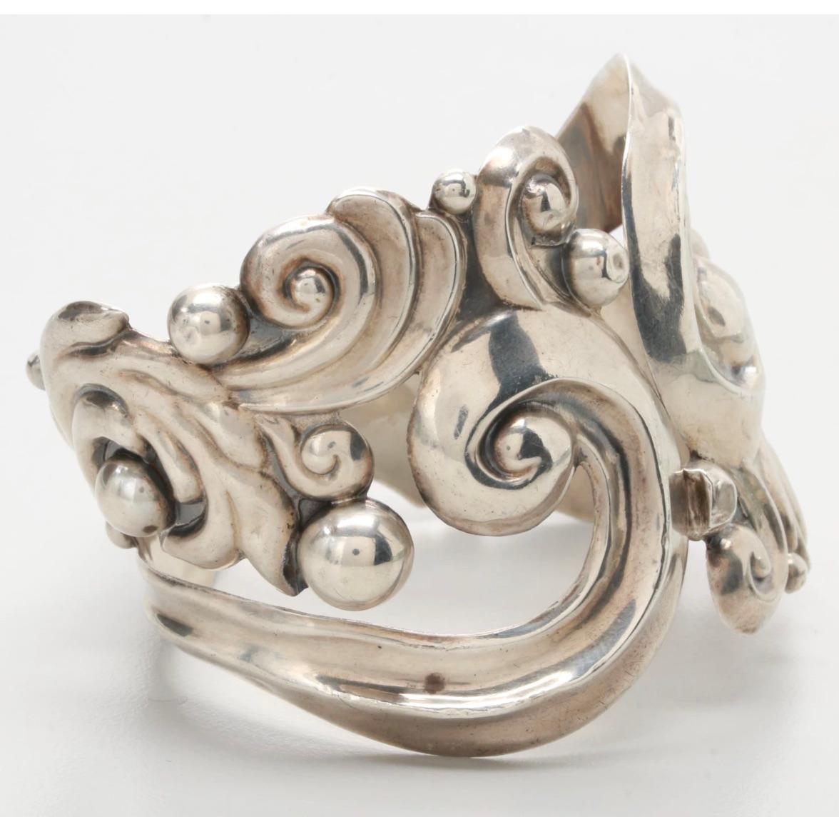 A rare 1950s vintage gorgeous Elaborate Design sterling silver
Mexico Clamper bracelet by a master artisan-Antonio Pineda
Clamper bracelet featuring flowing Repousse lines with ball accents swirling around the cuff; including an eagle stamp;