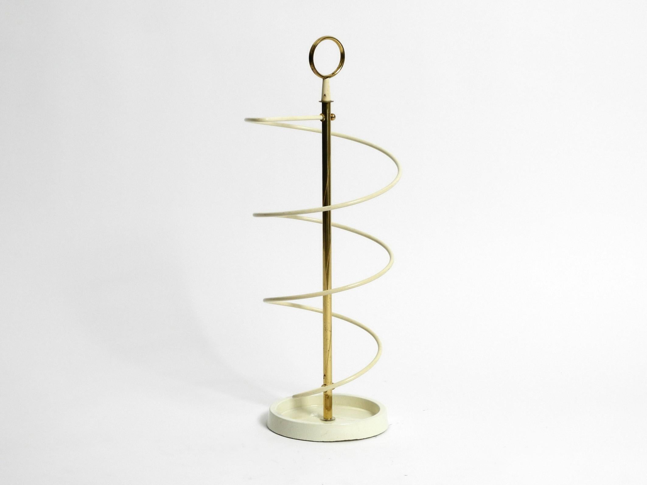 Exceptional rare Mid-Century Modern umbrella stand.
Very elegant minimalist string spiral design.
The base is made of cast iron and the metal spiral has a plastic coating.
The round handle is made of brass.
Very good condition without damages