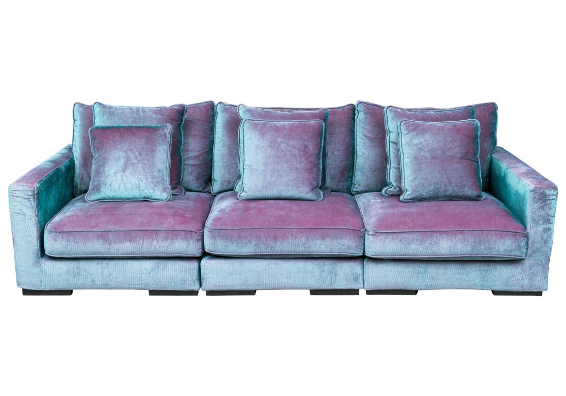 No longer in production, a Roche Bobois oversized three cushion Sofa impeccable custom upholstered in an incredible Blue and Red Corduroy which ingeniously utilizes the optic effect of the colors to create a sensational upholstery that changes color