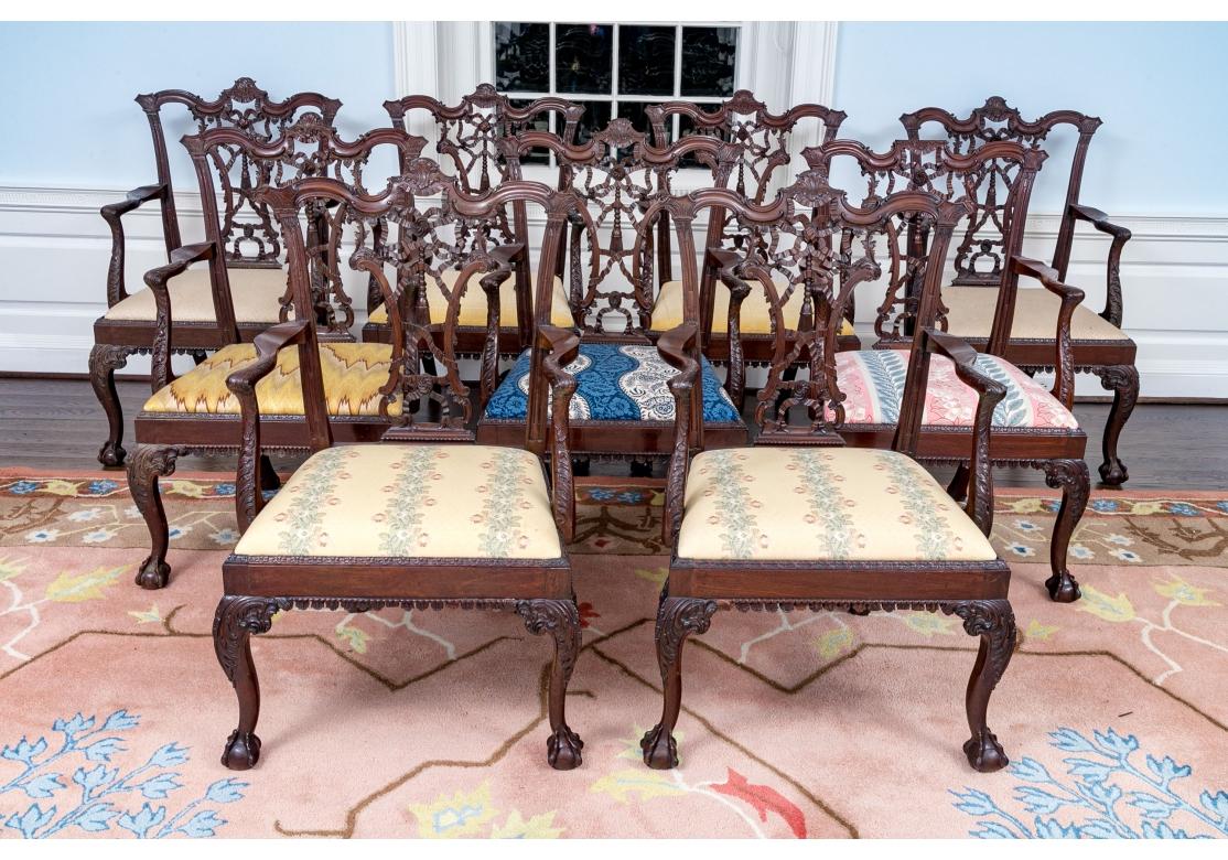 An early and very fine set of exquisitely carved Mahogany Arm Chairs in the Classic Georgian Style. With elaborate Ribbon  and Tassel carved back splats, Acanthus carvings on the Arms and Supports and a particularly fine Ball and Claw Foot. An