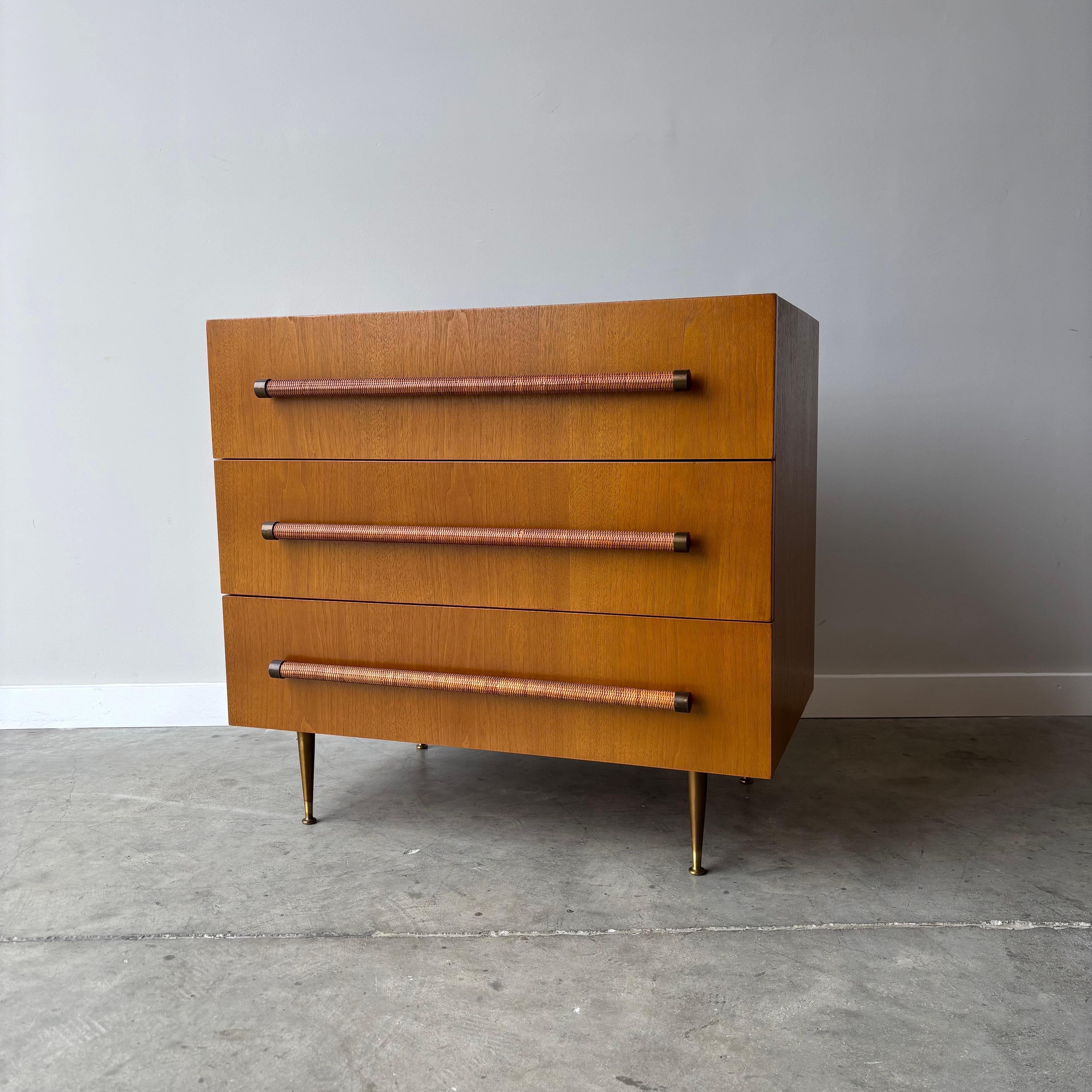 Una splendida cassettiera a 3 cassetti del designer T.H. Robsjohn-Gibbings.  Con la sua cassa minimalista, le gambe in ottone e i tiranti avvolti in canne, questo design è diventato un'icona del design moderno di metà secolo.  Questo mobile è stato