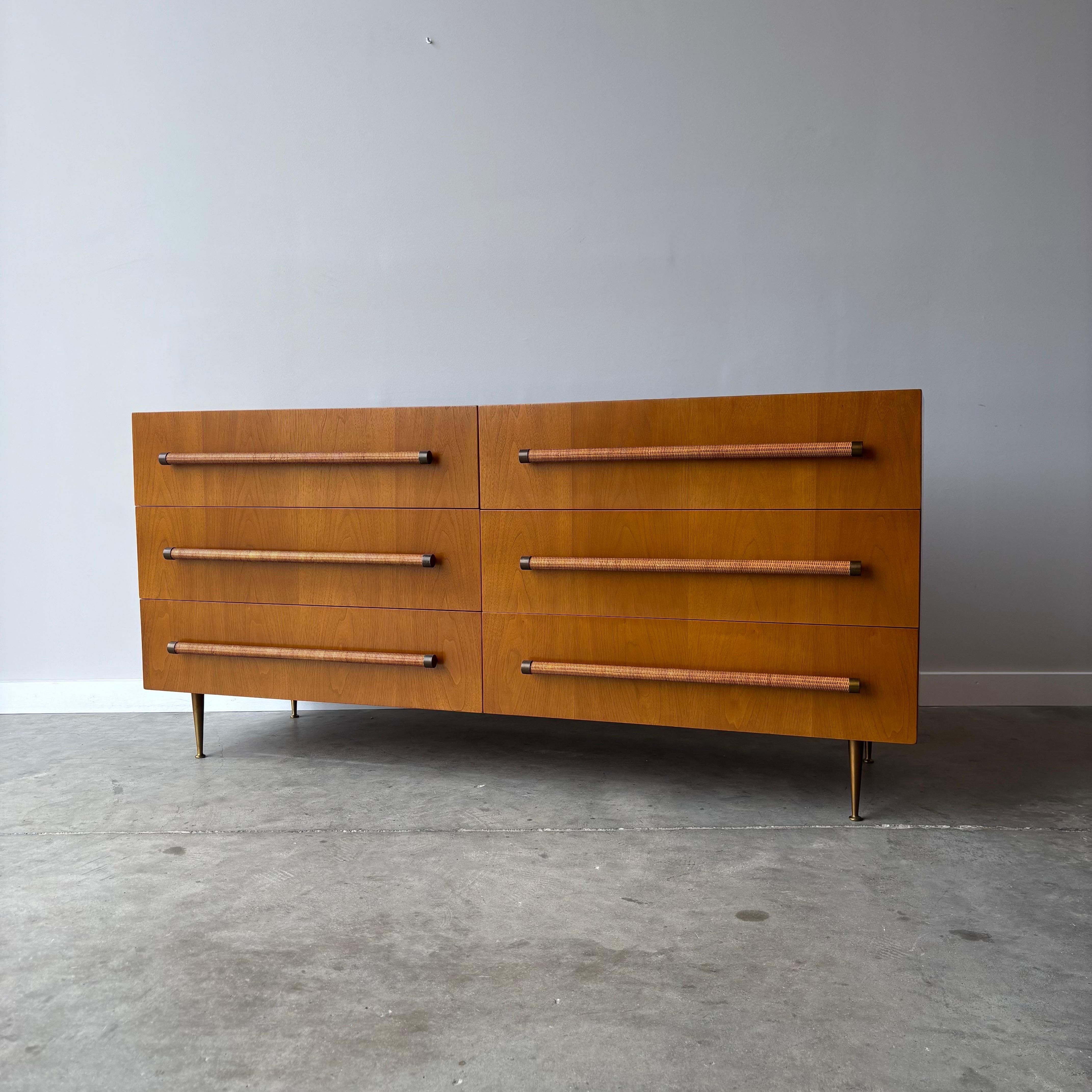 A stunning six drawer dresser by designer T.H. Robsjohn-Gibbings.  With its minimalist case, brass legs and cane-wrapped pulls this design has become an icon of mid century modern design.  This cabinet has been fully restored and showing only minor