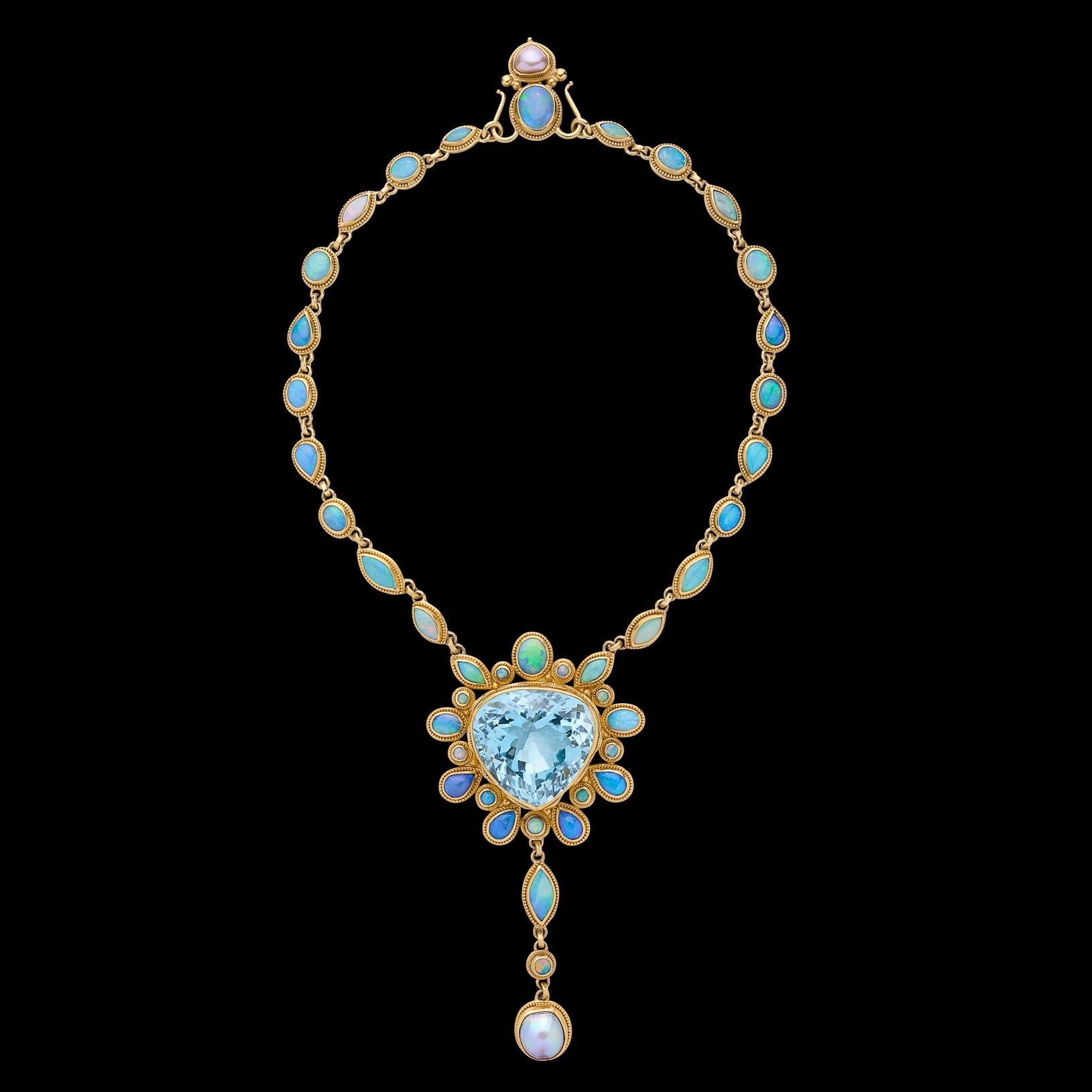 A true showstopper! This 22k and 18k necklace by designer Luna Felix showcases an exceptional pear shaped natural blue topaz weighing approximately 103 carats. The topaz is set amidst round, pear shape, oval and marquise cut opals with gorgeous play