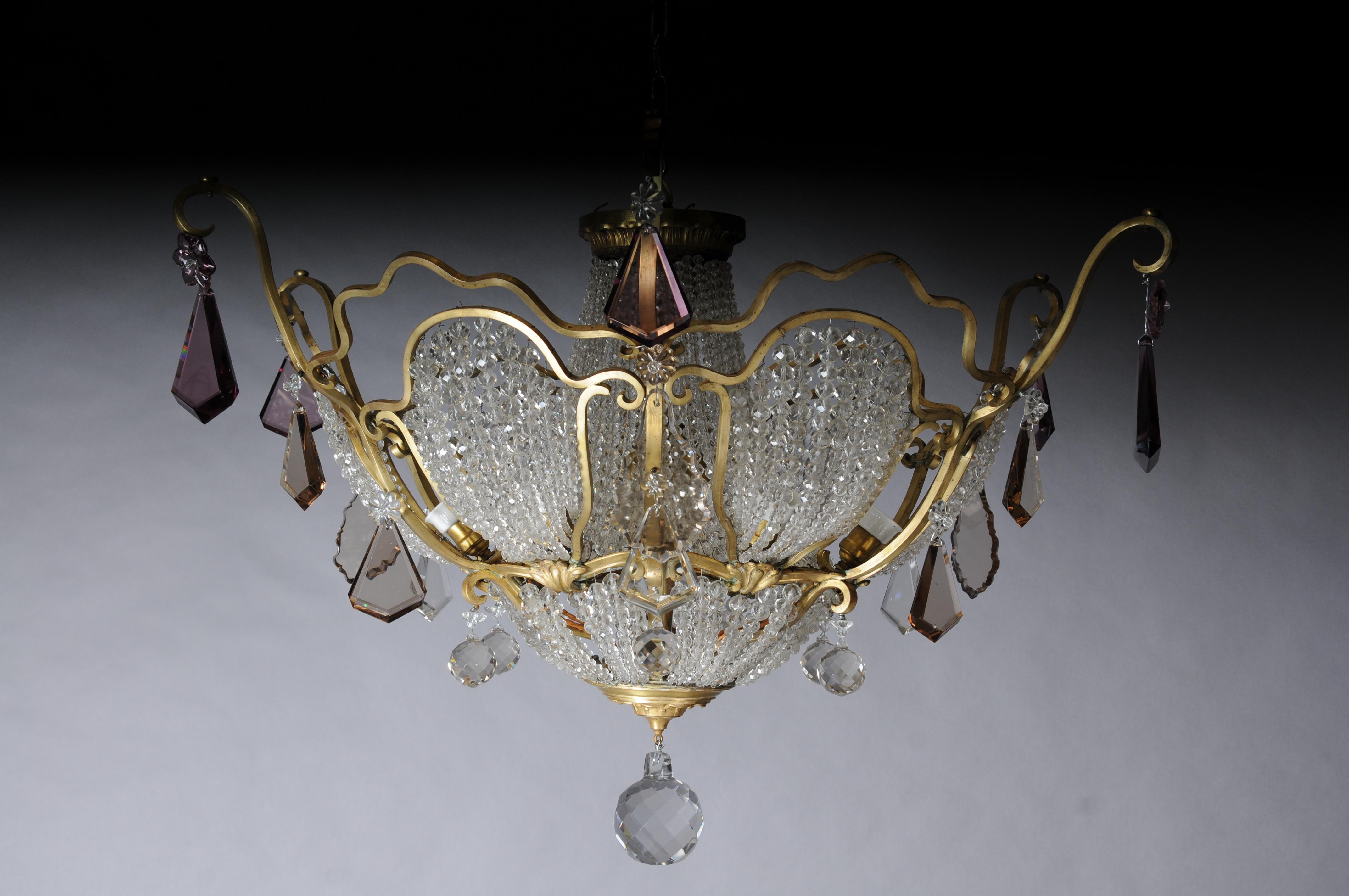 Extravagant antique crystal chandelier ceiling lamp around 1900

Brass body with richly cut crystal ball prisms. Additionally with tinted crystal hangings on the outside. France around 1900

Tested, electrified and ready for use