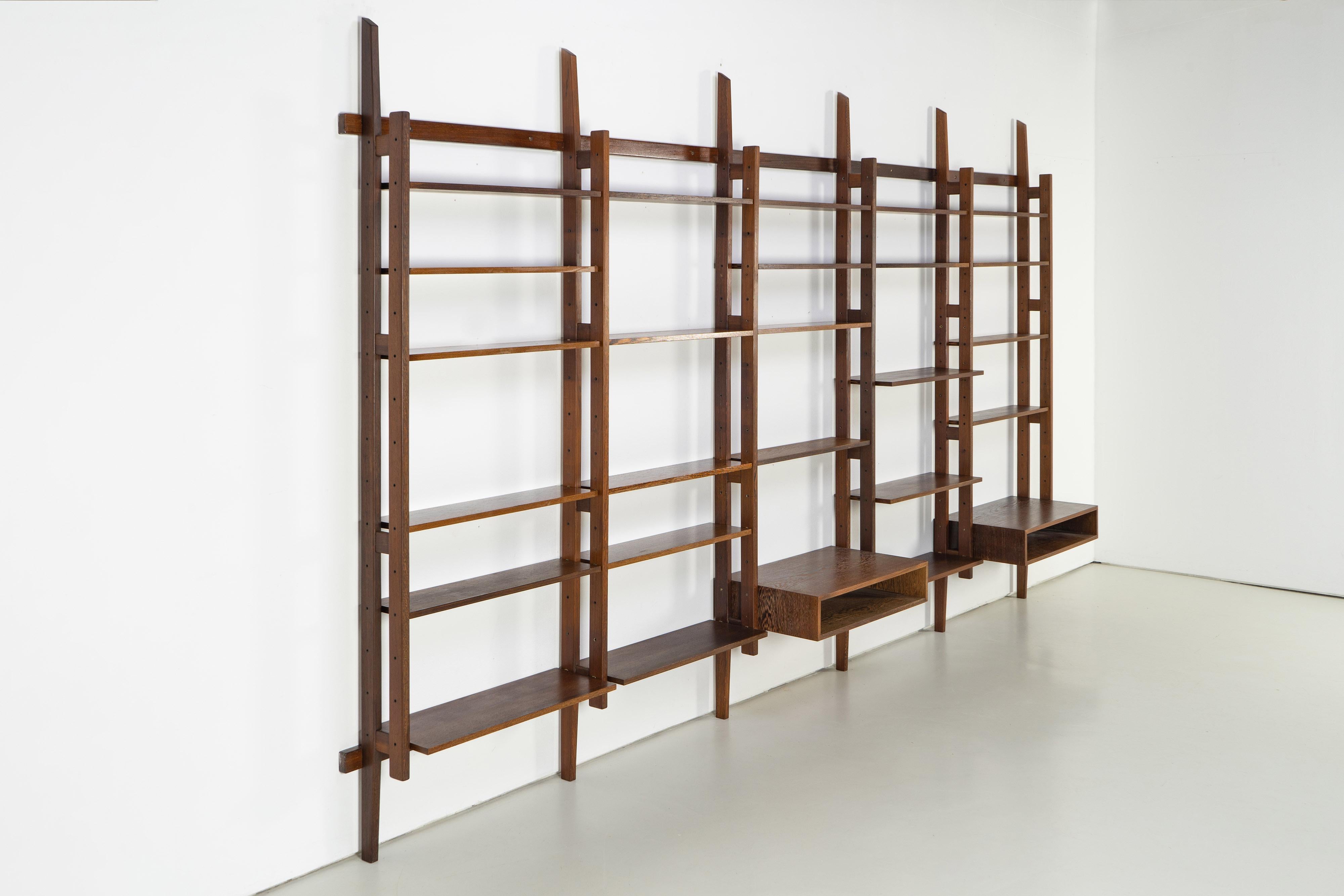 Large mid-century bookcase from the 1960s. The shelf is made of wenge. The shelf is characterized by the extravagant design of the wall ladders, which gives it a floating look, and the large number of shelves. Good condition with minor